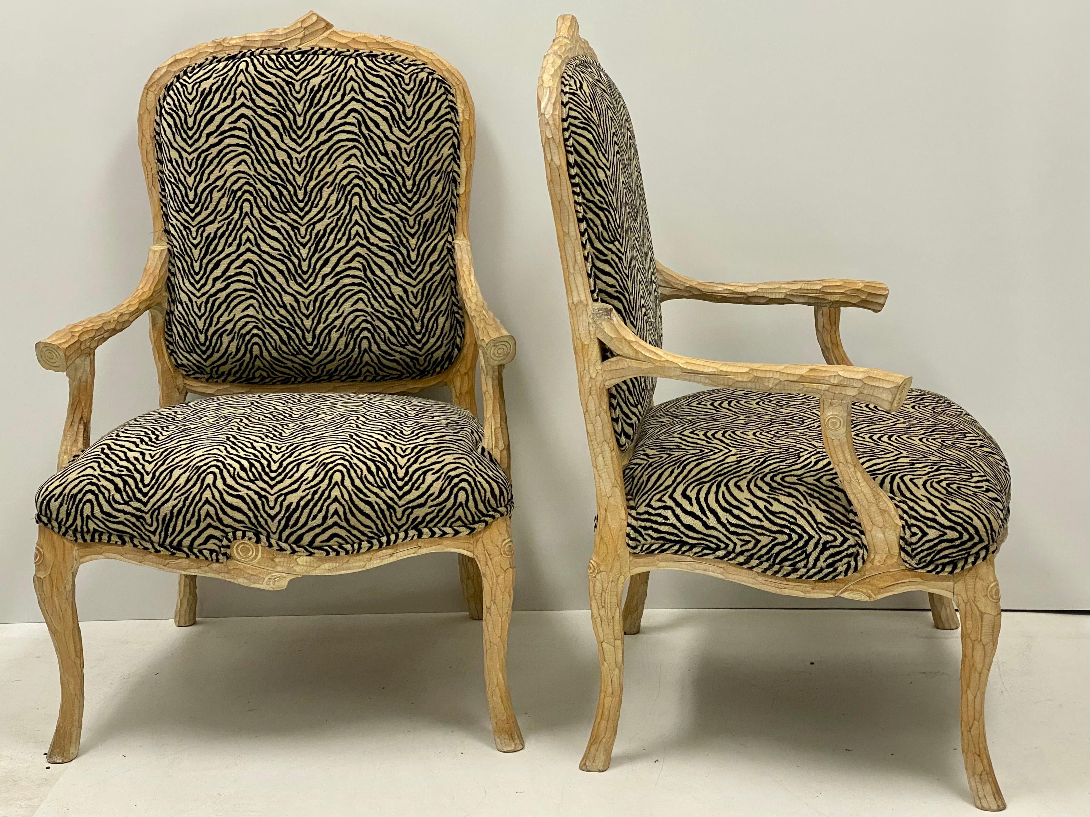 This is a pair of Italian bergère chairs. The faux bois frames are carved pine, and the upholstery, although not new, is in very good condition. They are unmarked. Measures: Arm 23.25”, seat 17”.