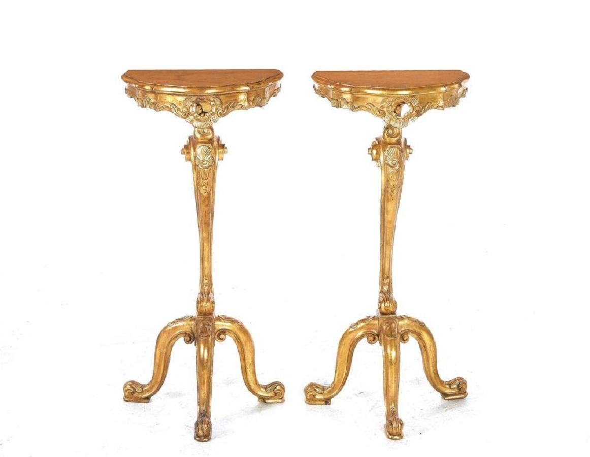 Pair of Italian Carved giltwood console or side tables, Late 19th century, D-shape top, pierced skirt, dolphin pedestal and feet.