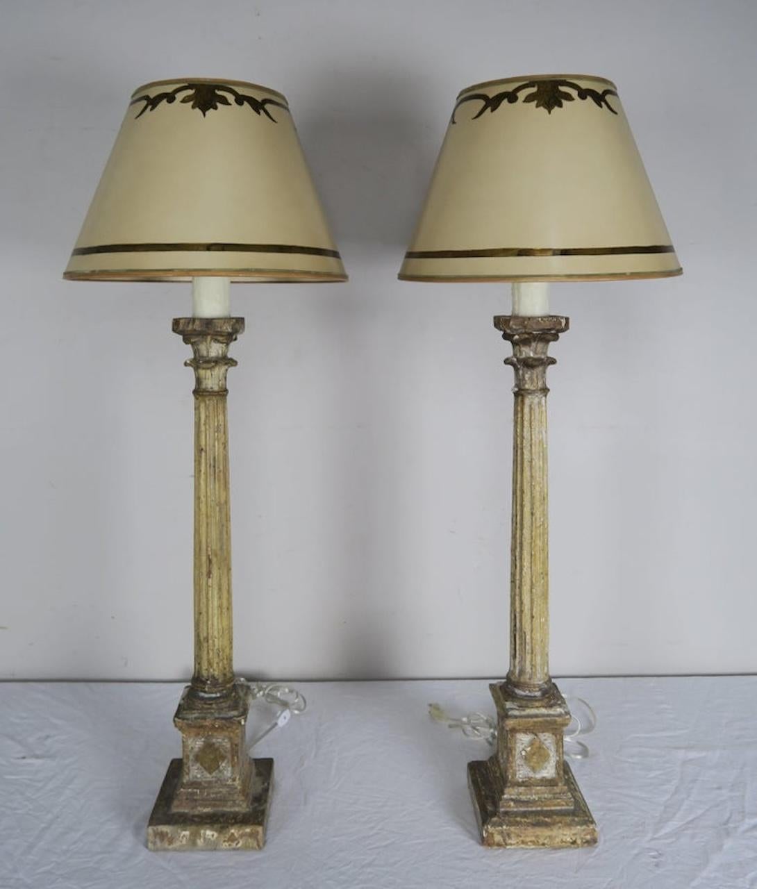 Paar italienische Kerzenständer im neoklassischen Stil aus bemaltem, geschnitztem Holz, die zu Lampen verdrahtet wurden, mit Kerzenakzent aus Tropfwachs. Die Lampen werden von handbemalten Pergamentschirmen gekrönt.