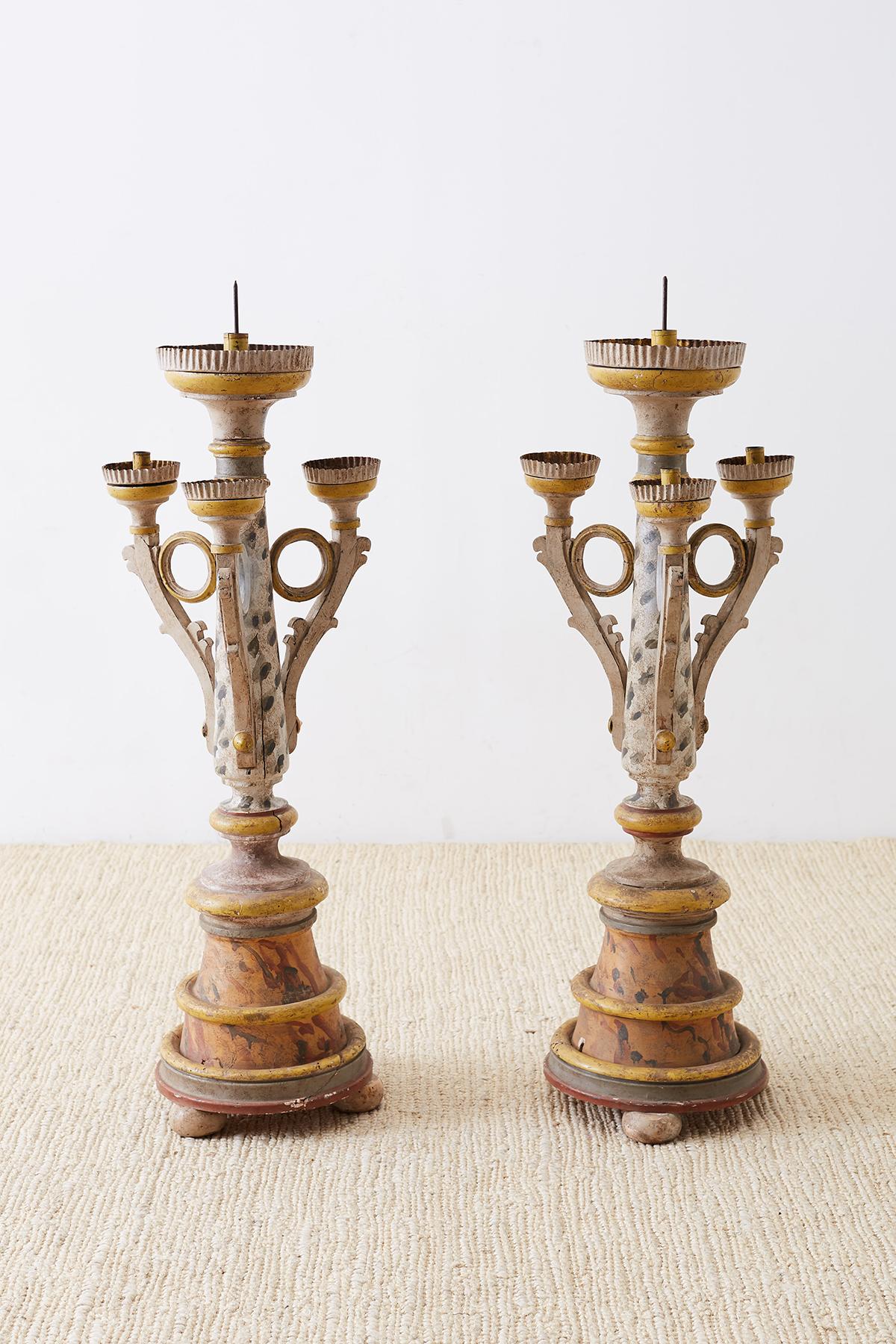 Polychrome pair of Italian carved three arm candelabras or candle holders. Features a decorative painted frame with yellow and red over a grey background done in a whimsical style. Distressed and faded patina with lots of character. Each arm has a