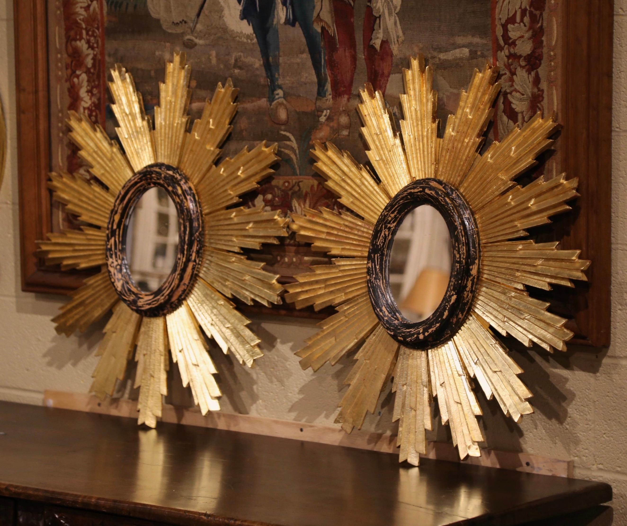 Add a beautiful shine to your home with this large pair of eye-catching sun mirrors. Created in Italy circa 2010, and almost round, each carved mirror has a classic sunbeam shape and a rich gold leaf painted finish. The oval center mirror is set