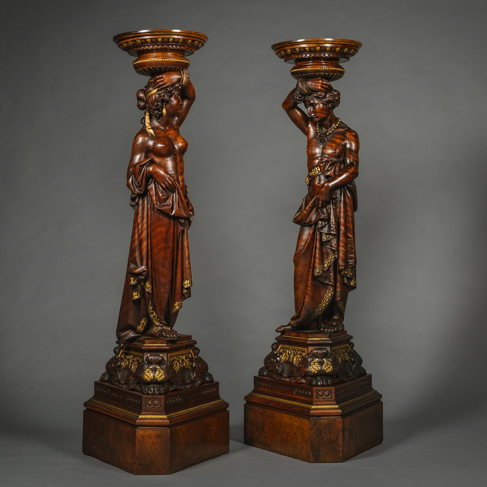 A Fine Pair of Italian Carved Walnut and Parcel Gilt Figural Torchères by Angiolo Barbetti, (1805-1873) Florence. 

Signed 'Barbetti', 'Anno 1866', 'Firenze'.  

Each torchère finely carved in the Renaissance revival style as classical Grecian