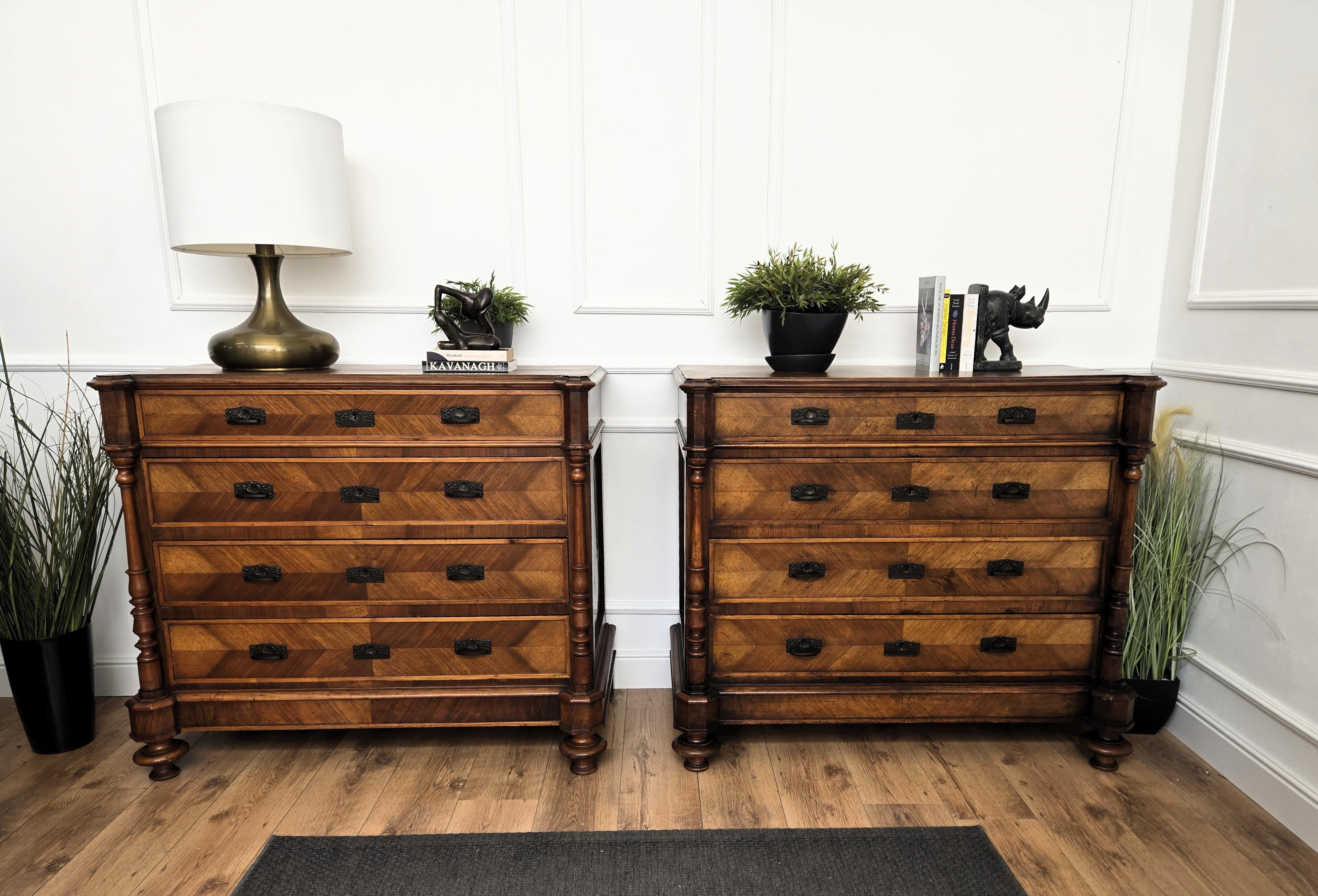 Very elegant Italian pair of chest of drawers sideboard credenza in beautiful veneer walnut wood,  with four central drawers and greatly decorated carved side columns, standing on classical bun feet with dark brass details as the handles and locks.