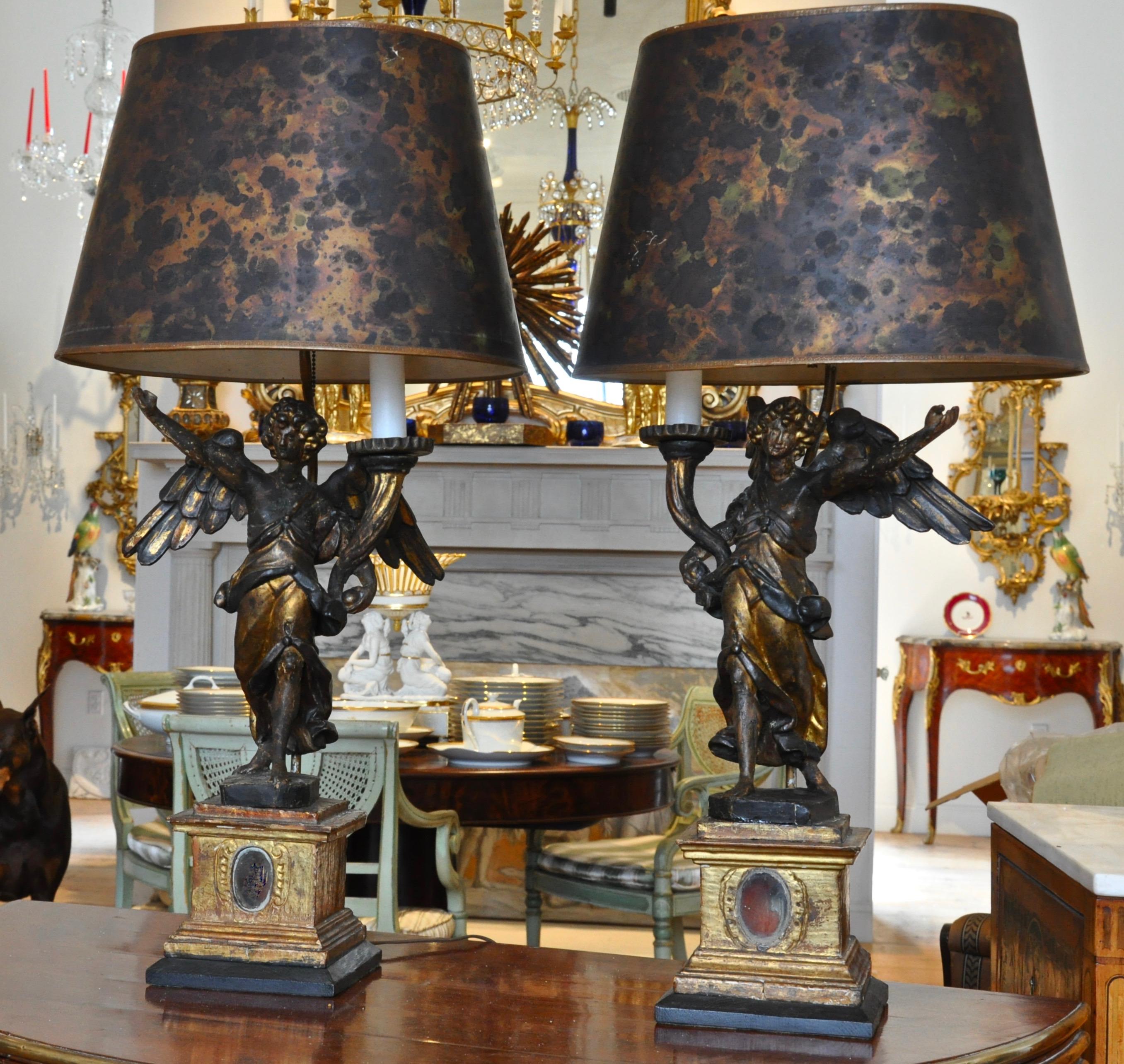 Pair of early 17th century Italian carved wood and gilt angel Pricket stick candelabra.

Jubilant Angels Holding Cornucopia which holds single pricket for a candle. Each now mounted as lamps. Early and original surfaces showing quite the age and
