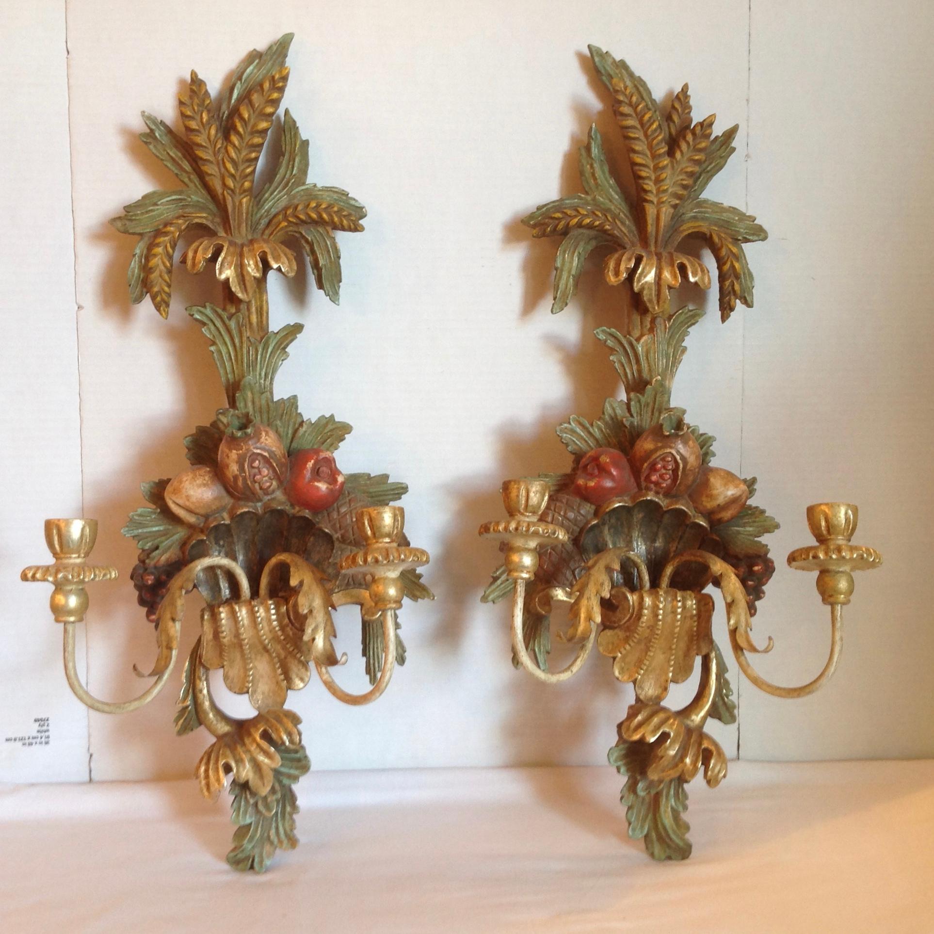 Elaborately and extensively carved fruit form sconces of large
dimensions. The carvings are accented with a central shell cartouche.
They are fitted for candles.