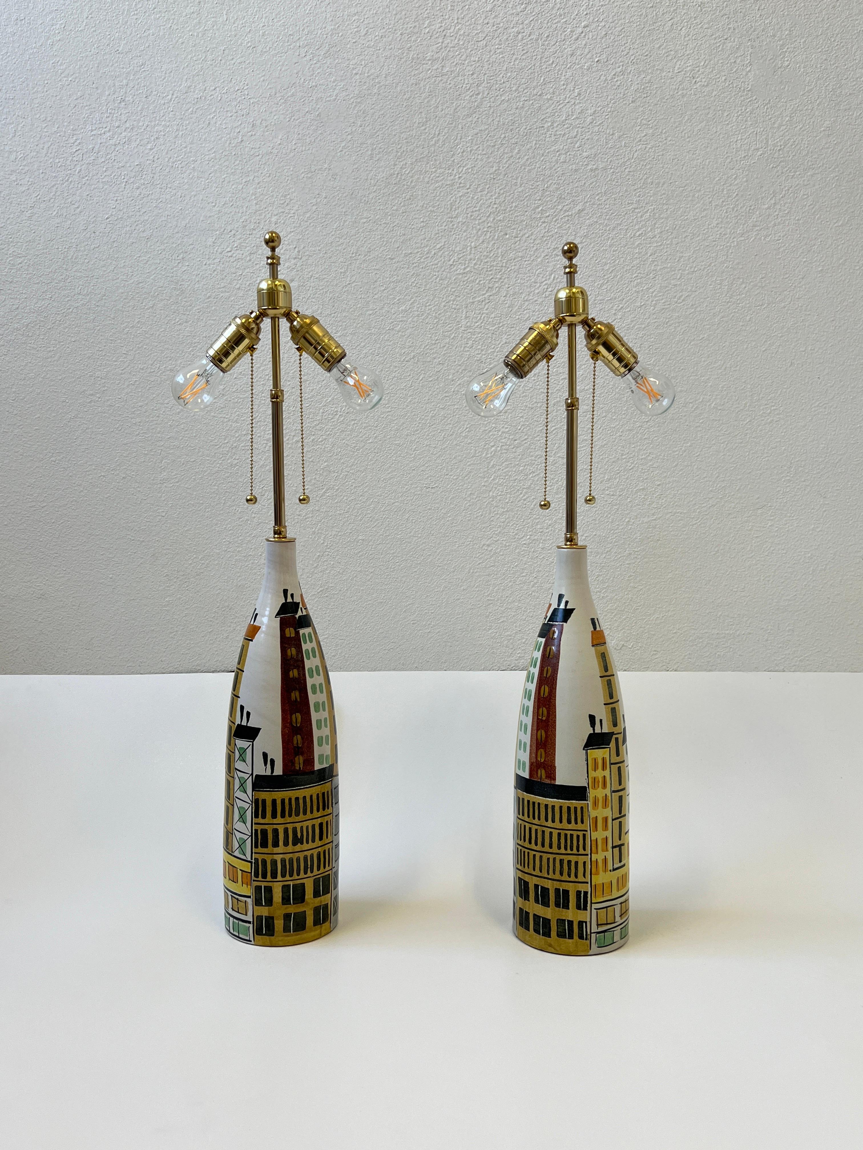 1960’s Italian ceramic and brass pair of cityscape table lamps by Aldo Londi for Bitossi.
Newly rewired with solid brass two bulbs adjustable clusters, brown cloth wrapped cord and new vanilla linen shades. The bases are marked made in Italy.