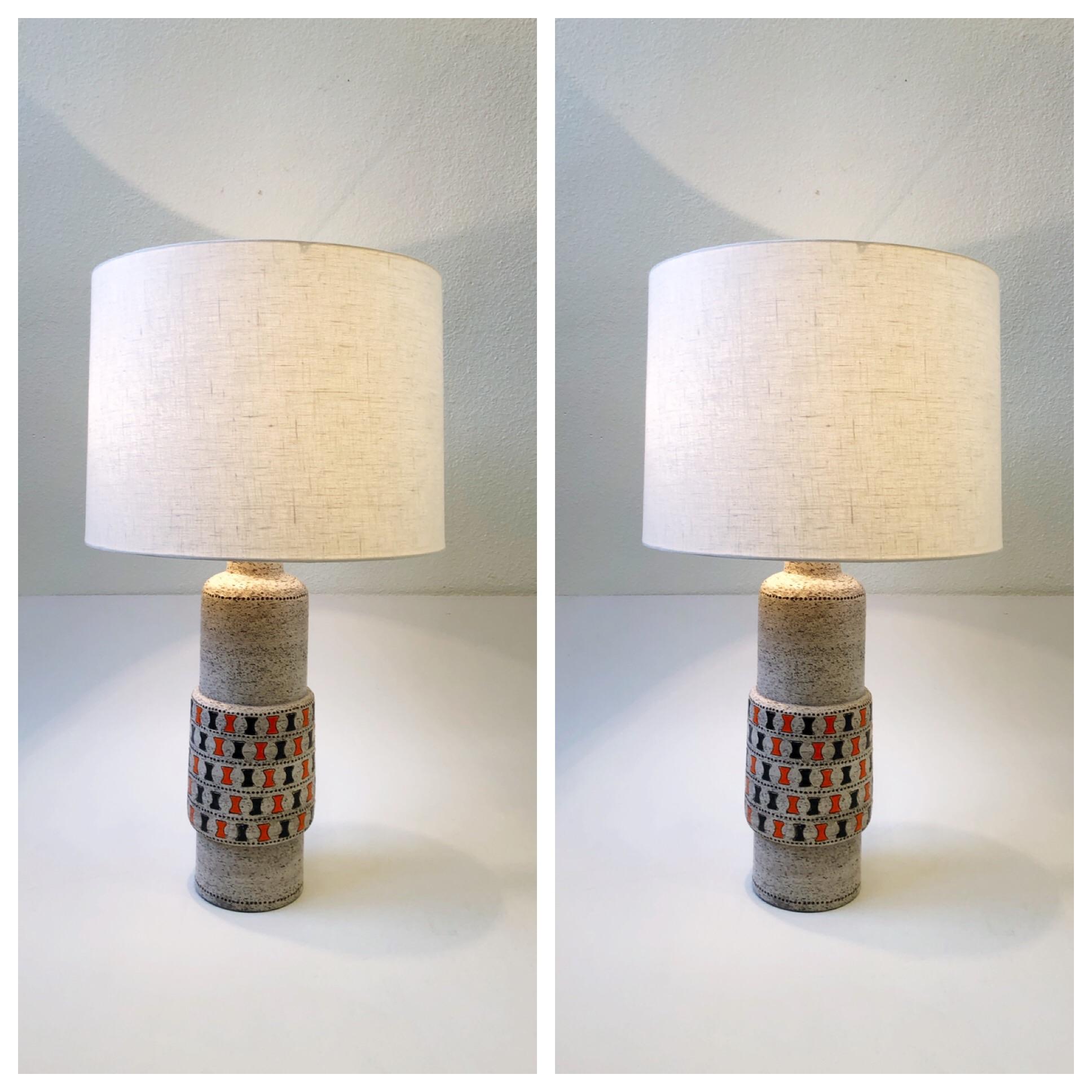 A spectacular 1960’s rare pair of Italian Ceramic black and orange “Dente” Table Lamps by Aldo Londi for 
The lamps have been newly rewired with new polish brass hardware and new vanilla linen drum shades. 
Overall dimensions: 31.5” high 18”