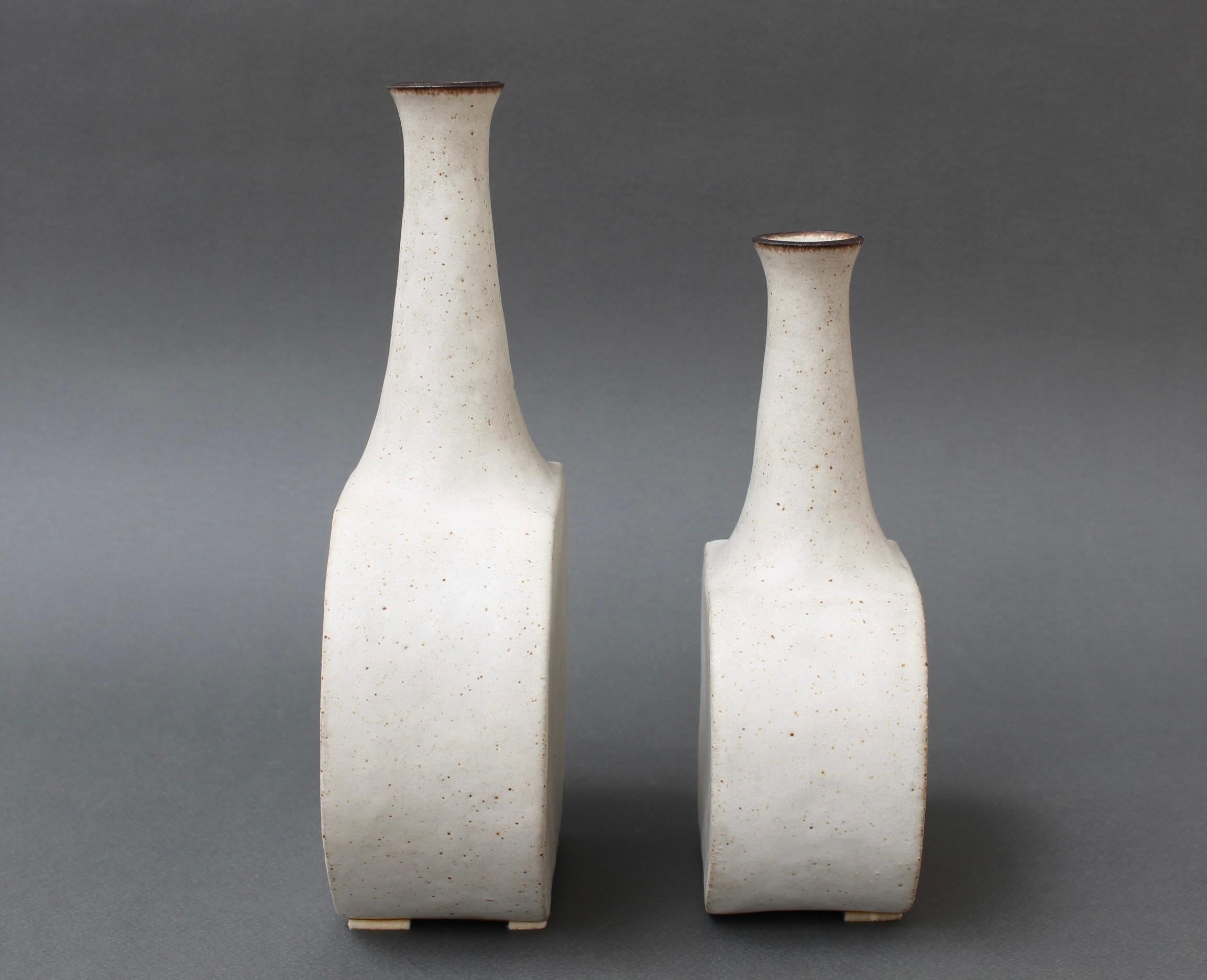 Pair of Italian ceramic bottles with chalk-white surface and lightly chocolate brown highlights by ceramicist Bruno Gambone, circa 1980s. These graceful pieces are composed of elegantly narrow-openings united over a sensuously elliptical body. They
