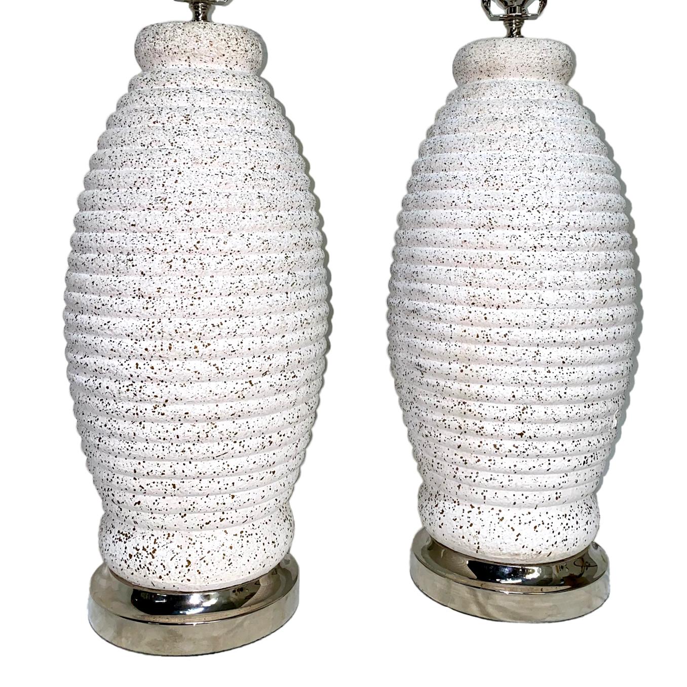 A pair of white circa 1950's Italian ceramic lamps with mottled surface and silver-plated bases.

Measurements:
Height of body: 19