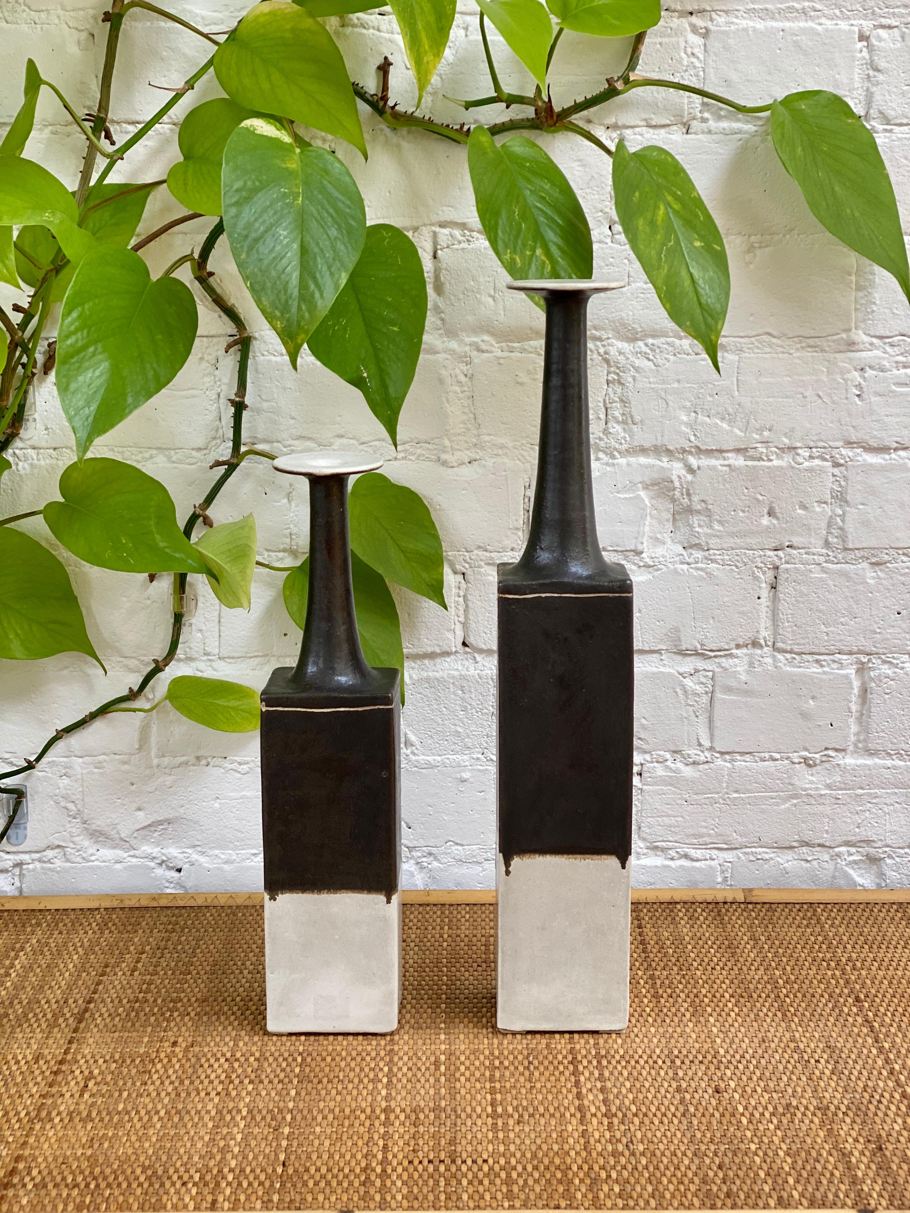 Pair of tall ceramic vases with darkened glazed top and drip motif over a white base, by ceramicist Bruno Gambone, circa 1970s. This pair of graceful, narrow-opening flower vases are stunning works of art and of sizeable stature. With a modern