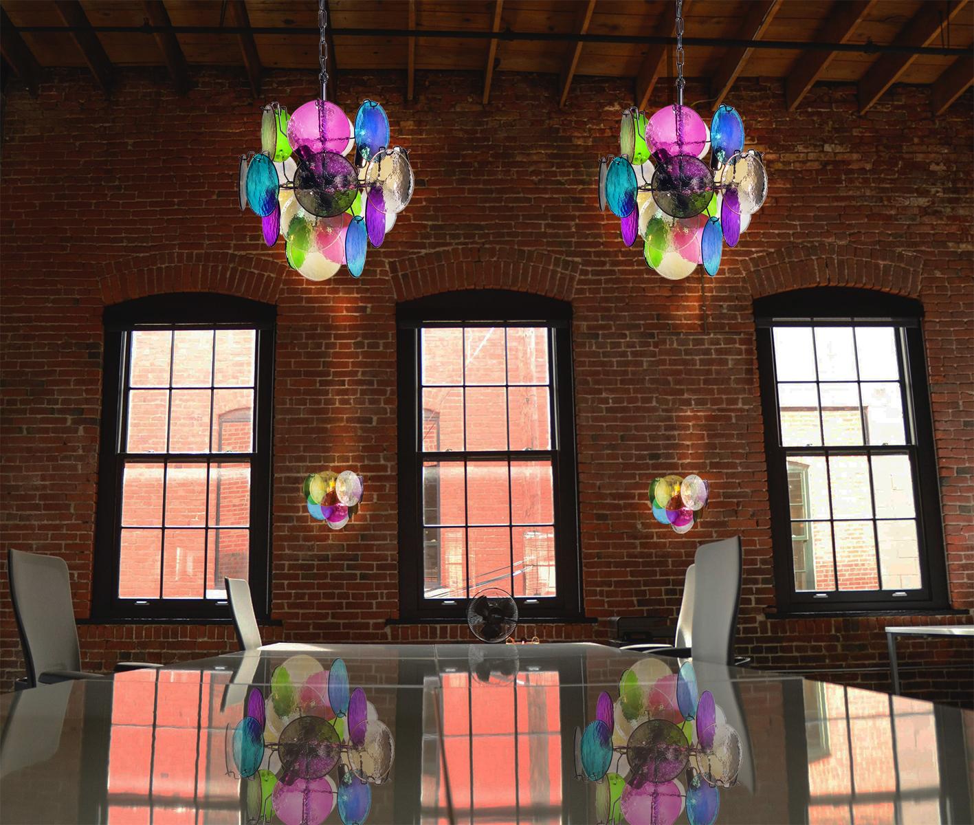 Pair of vintage Italian Murano chandeliers in Vistosi style. The chandelier has 24 fantastic Murano multicolored disks in a metal frame.
Period: 1980s
Dimensions: 41.30 inches (105 cm) height with chain; 20.50 inches (52 cm) height without chain;