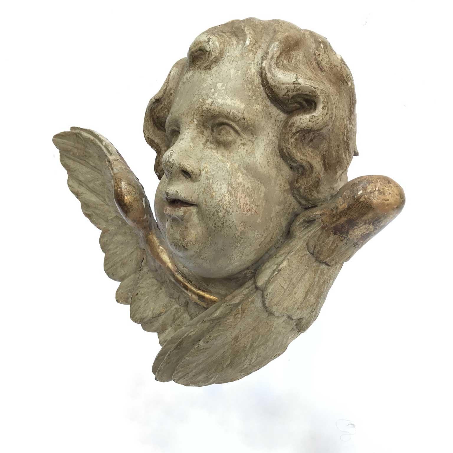 Pair of antique Italian figurative sculptures cherub heads dating back to mid-18th century, two carved linden wood curled angel heads figures, with later painting.
The pair of this antique winged putti heads should be originally part of a