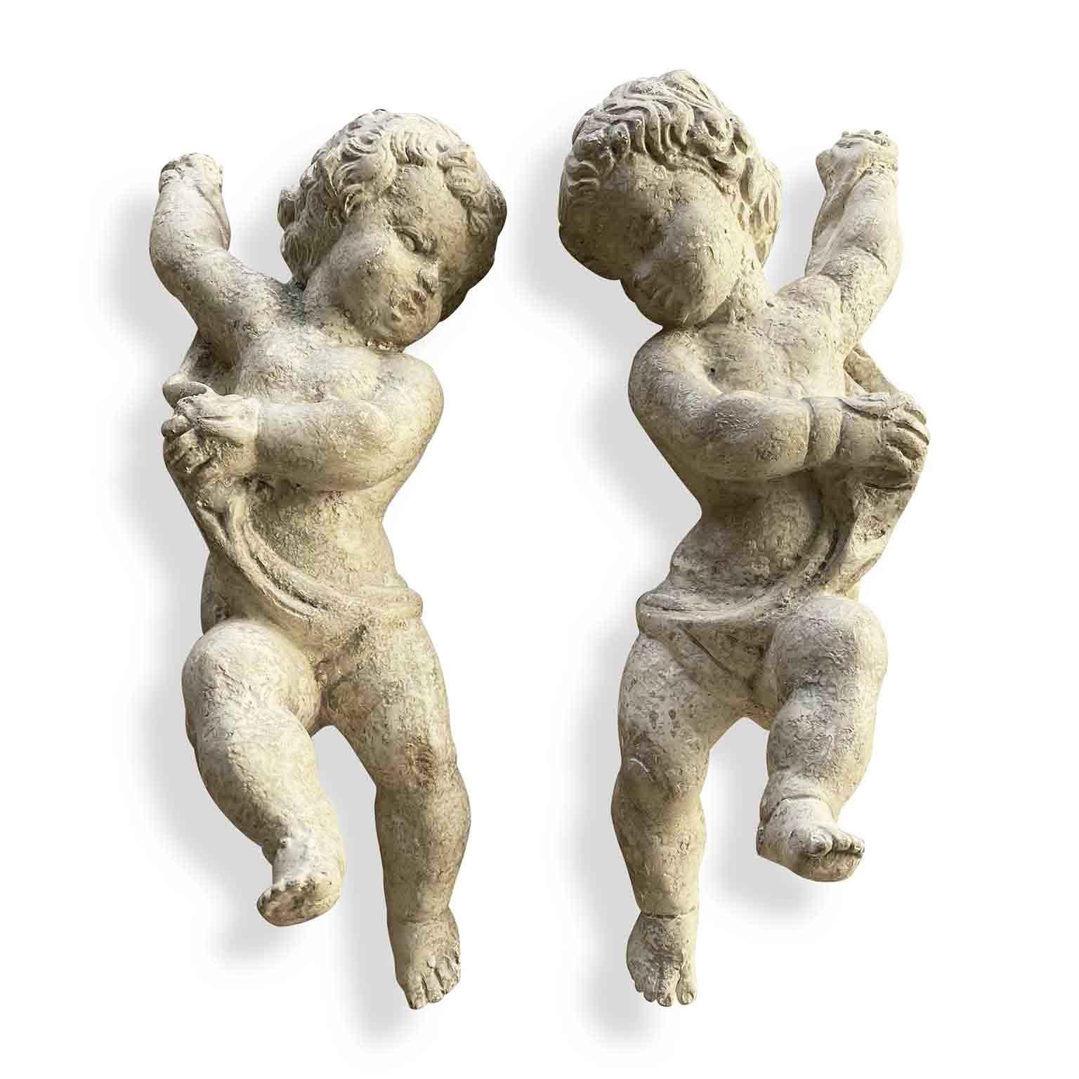 Lovely pair of 19th century Baroque style angels, putti sculptures hand-carved in lime tree, of Italian origin, dating back to 1850 circa in overall good condition.
This pair of antique wall-hanging putti figures have a white-ivory color gesso