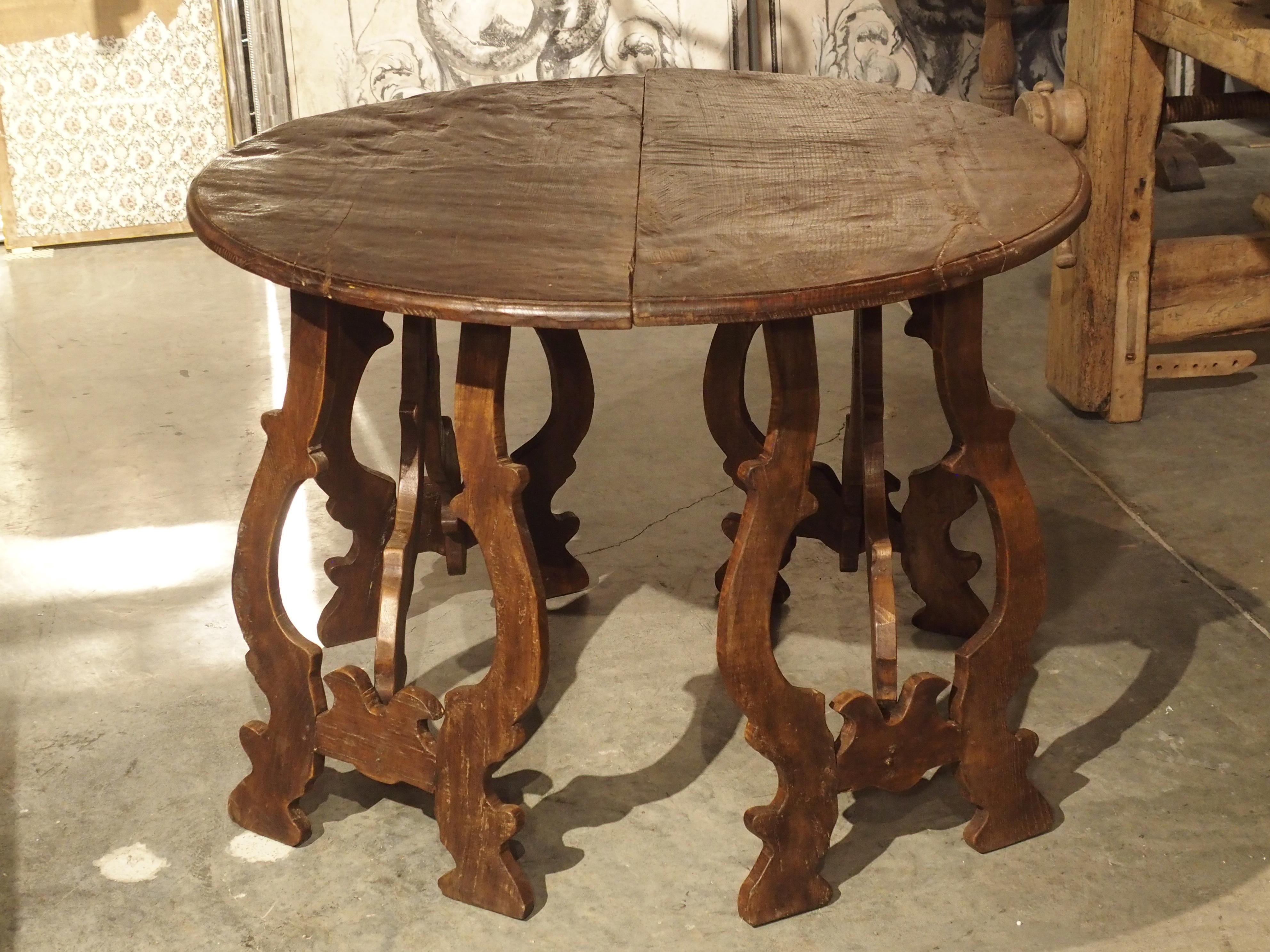 These demilune tables are carved from old planks of Italian chestnut. Tables like this were first used in Italy and Spain in the early 1600s and really never went out of fashion. When not in use as a center table, they can be separated and used