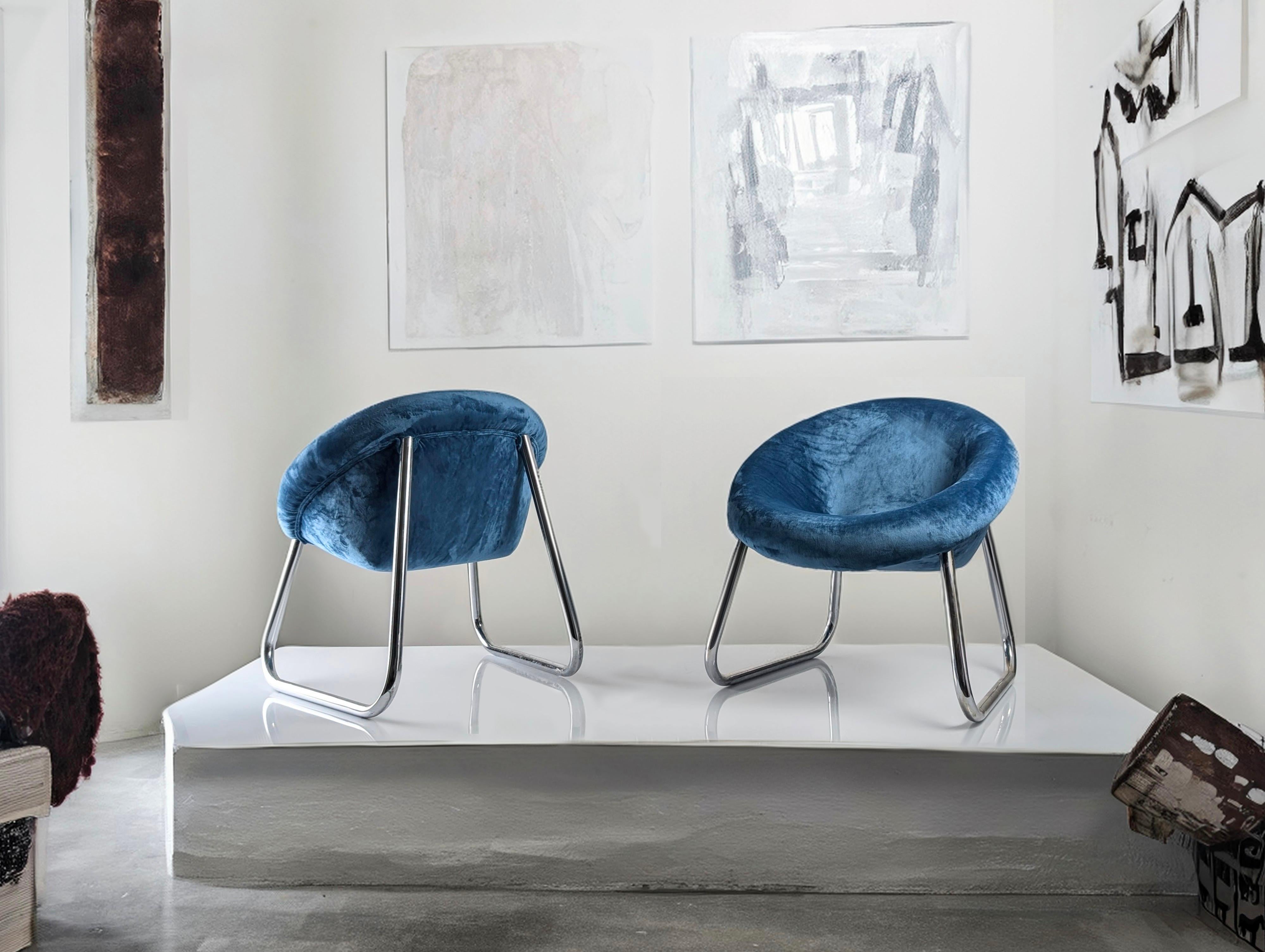 Pair of Italian designed armchairs from the 1970s that capture the elegance and essence of the period with an impeccable balance between structure and comfort. The chrome metal base forms an enveloping and light contour, enhanced by the deep blue