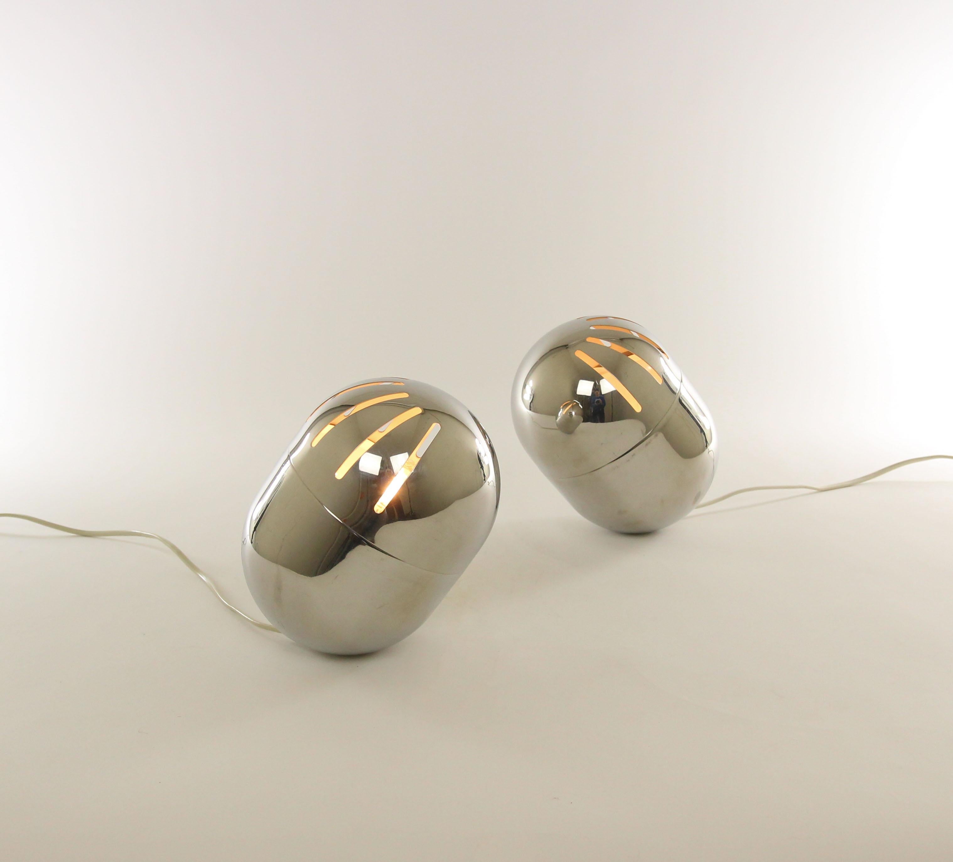 Pair of chromed table lamps produced by Reggiani, probably from the 1970s.

The top part of the lamp, which is rotatable, contains eight elongated openings through which the light emanates in a playful way. The bottom of the lamp is relatively
