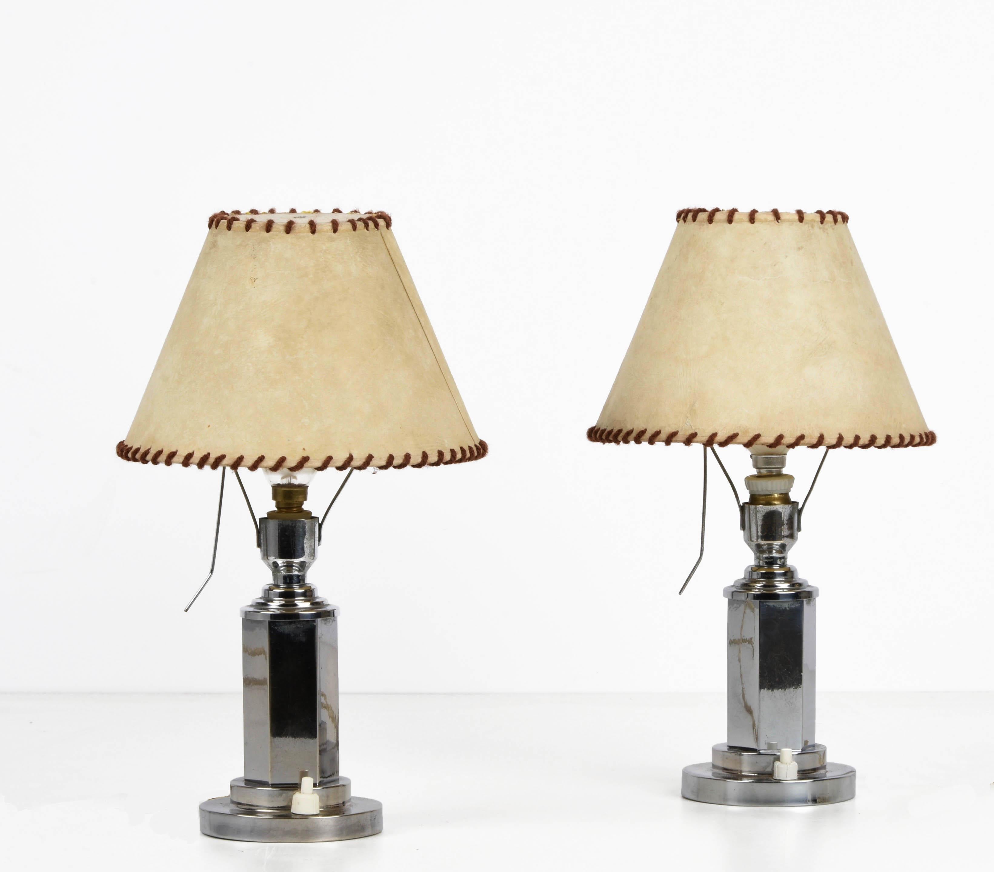 Amazing pair of small chrome table lamps with adjustable white parchment lampshade. This wonderful pair was produced in Italy during the 1940s.

These fantastic pieces are fitted with small E / 14 bulbs, the chromed base is perfect because reflect