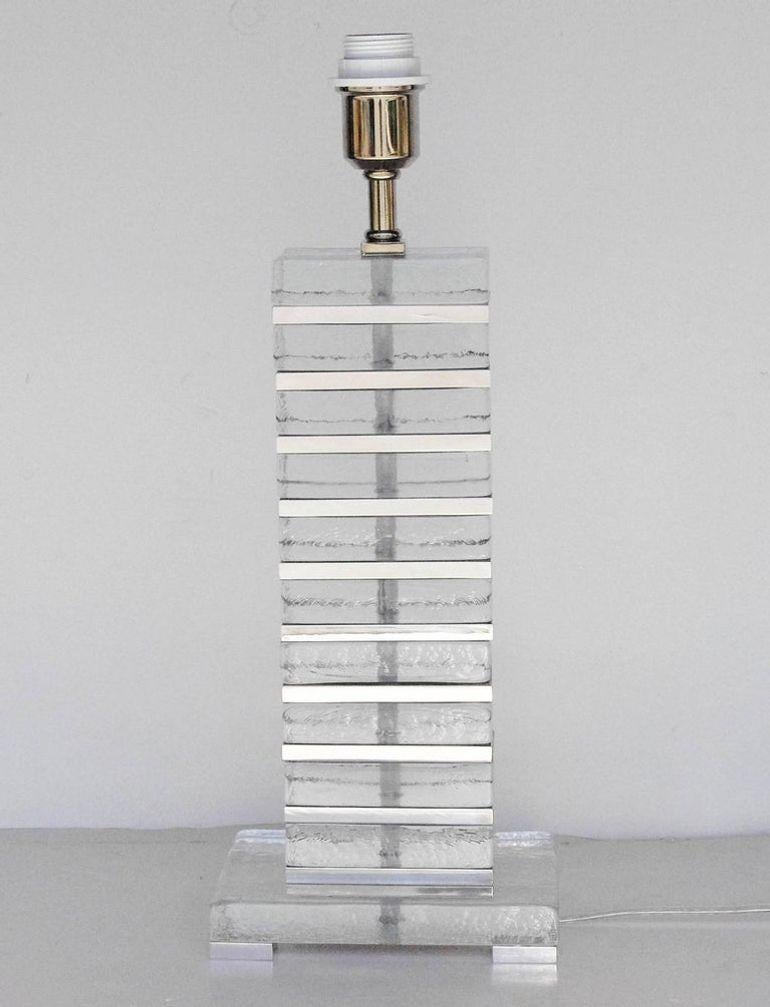 Sophisticated pair of Italian table lamps crafted in the 1990s, featuring stacked clear Murano glass blocks with polished chrome accents. Each rectangular glass block is hand-blown, showcasing the clarity and craftsmanship associated with Murano