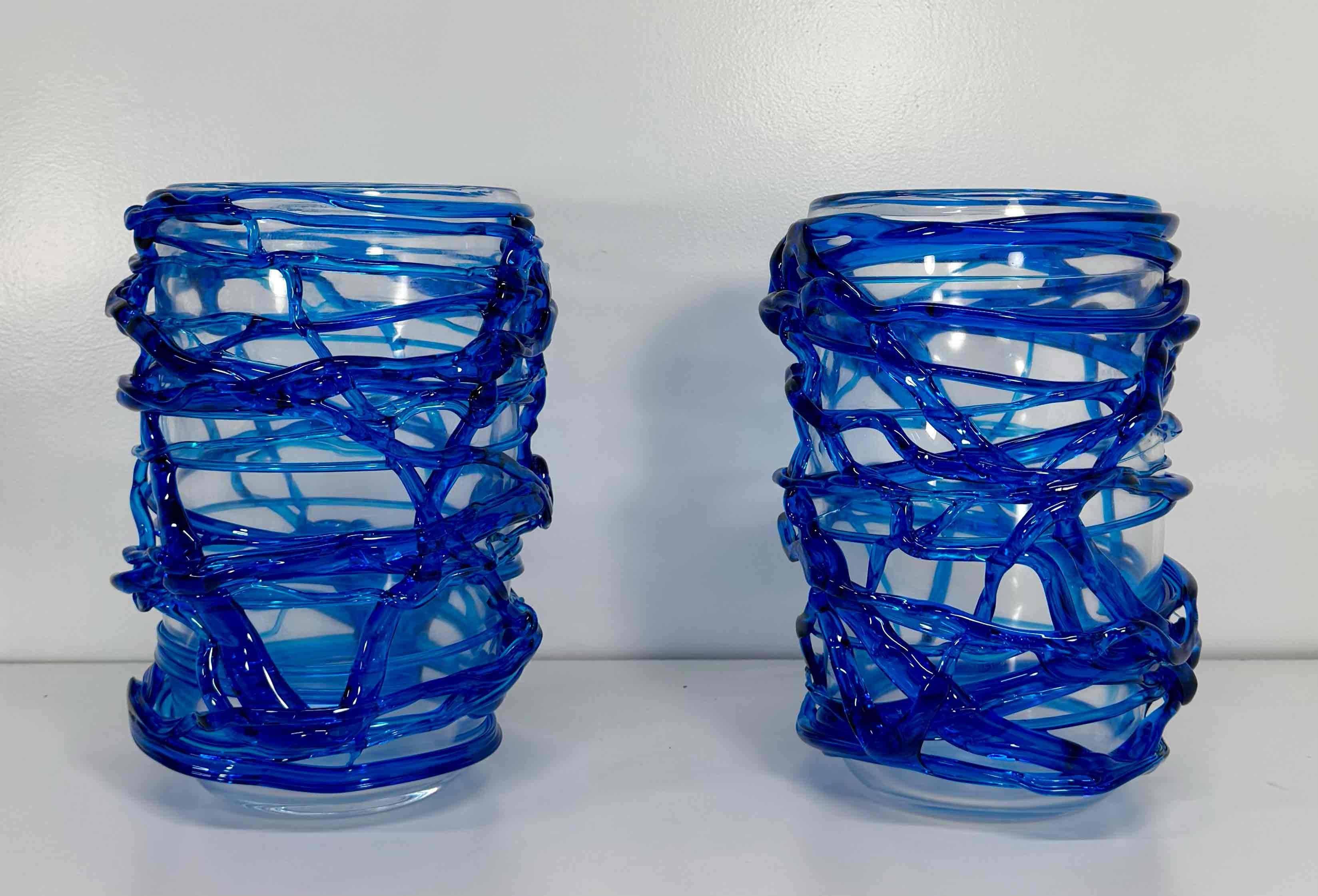 Questa coppia di vasi in stile Art Déco è stata prodotta in Italia, più precisamente a Murano (Venezia), la capitale mondiale dell'arte e dell'artigianato del vetro.
Sono interamente realizzati in vetro di Murano trasparente e blu, finemente