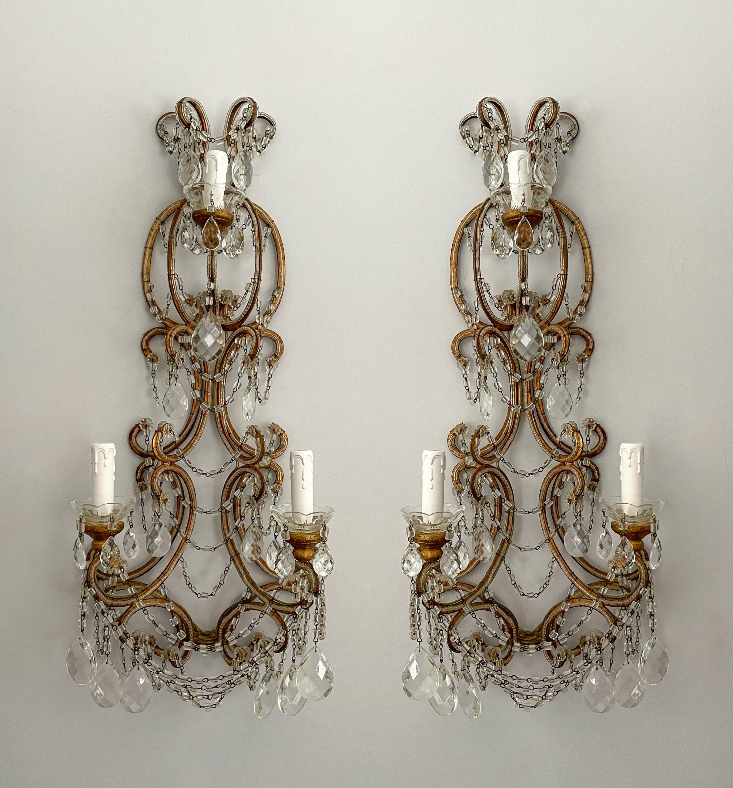 Exquisite, pair of Italian vintage gilt-iron and crystal beaded sconces. 

Each sconce features a hand scrolled and gilded iron frame outlines with small glass beads. “Macaroni” glass beads and faceted prisms complete the look subtle opulence. 

The