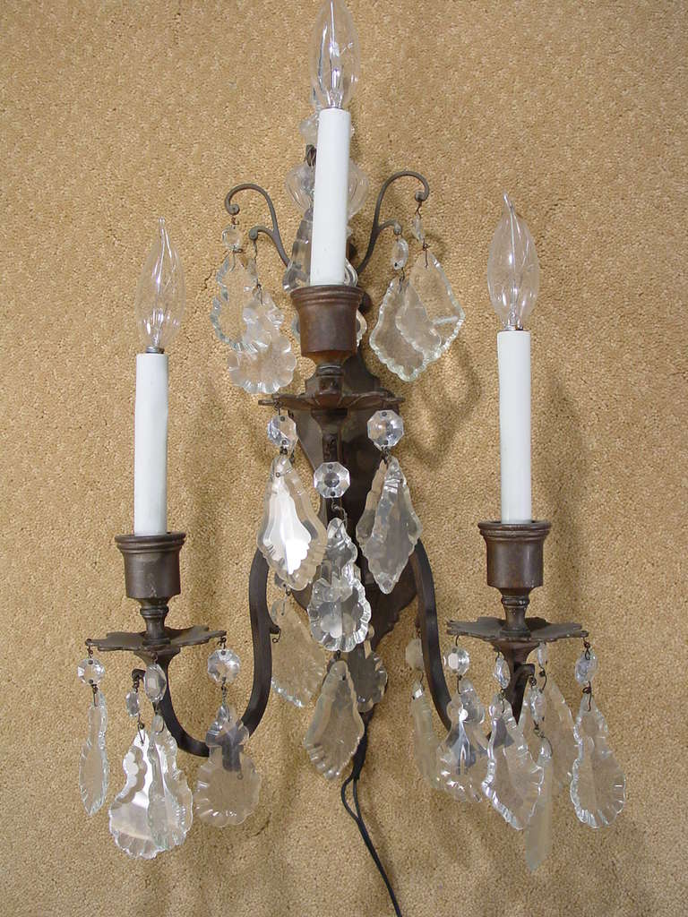 Pair of Italian bronze and crystal wall sconces featuring beautifully cut crystal beads and accents. Each sconce has three lights.

 