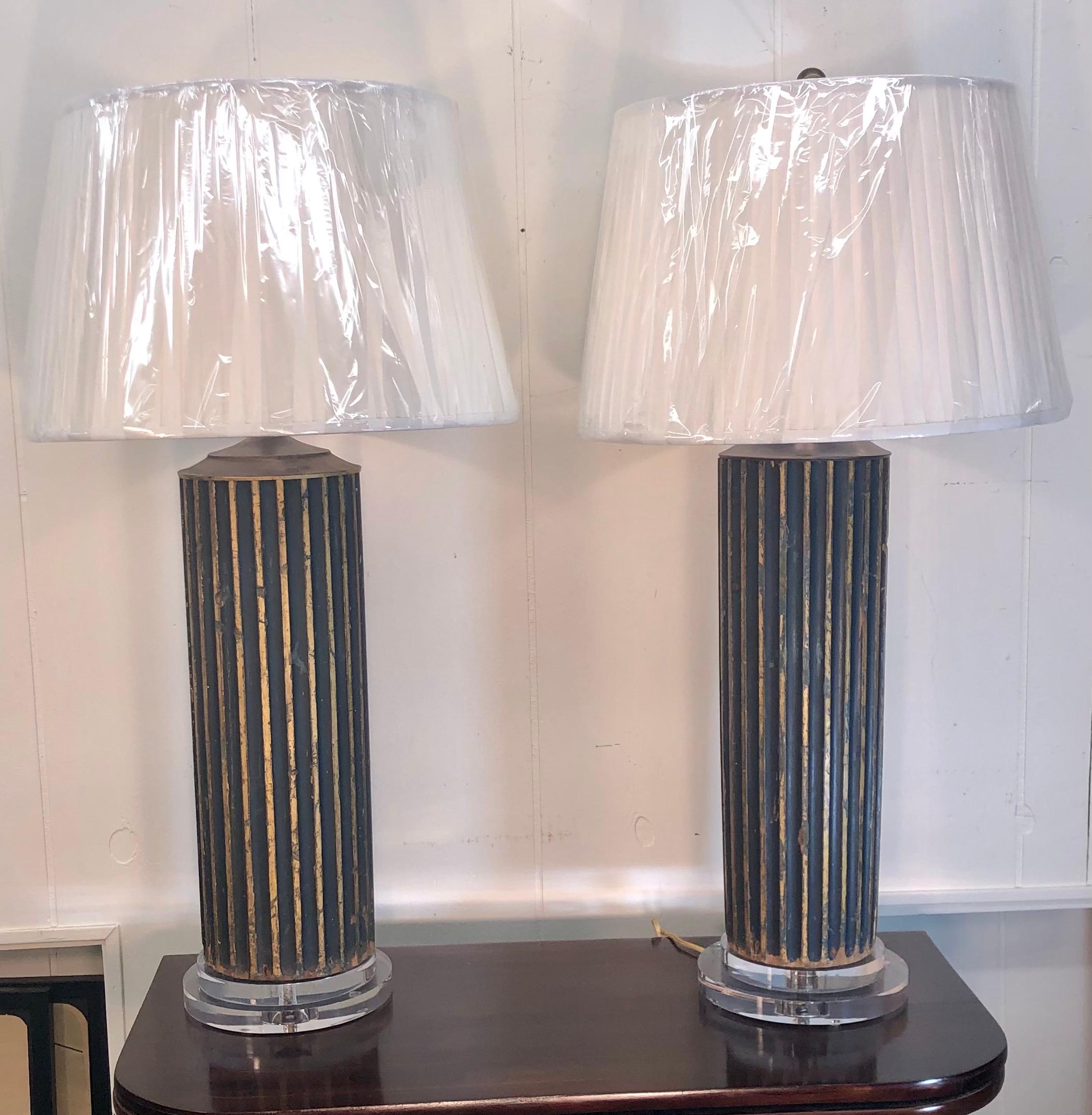 Italian dark verde fluted wood column lamps with hints of dark blue and gilt highlights between the flutes on front half of the columns on Lucite Bases. There are six lamps available. The lamps will be sold in pairs. Shades not included.
 
