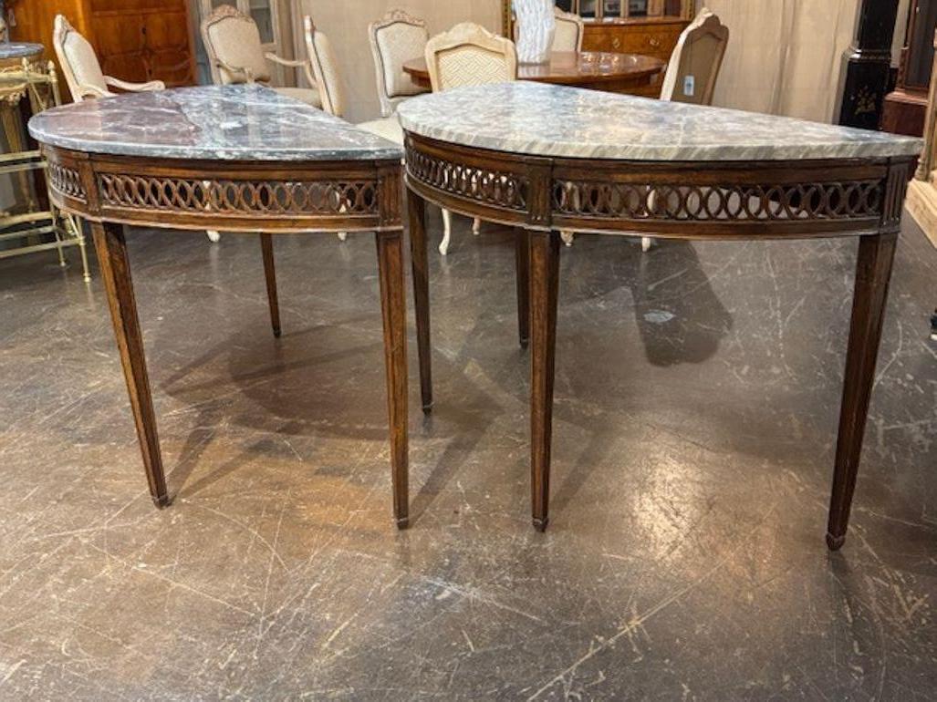 Paire de consoles italiennes du 19e siècle en noyer sculpté et à dessus en marbre demi-lune. Une paire de consoles italiennes en demi-lune, combinant d'élégantes silhouettes en demi-lune avec de riches finitions en bois ou en vermeil, est très