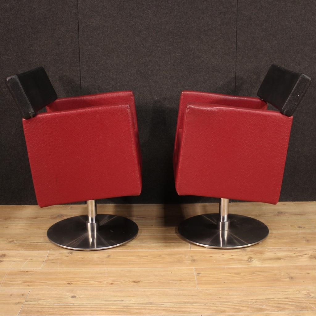 A superb pair of Italian design armchairs in faux leather, 20th century. 

Pair of Italian design armchairs from the 1970s-1980s. Furniture with round metal base covered in the seat and back in red and black faux leather (skai). Armchairs of