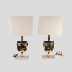 Pareja de Lámparas de Mesa Máscara de diseño italiano fundidas en latón y base de mármol travertino