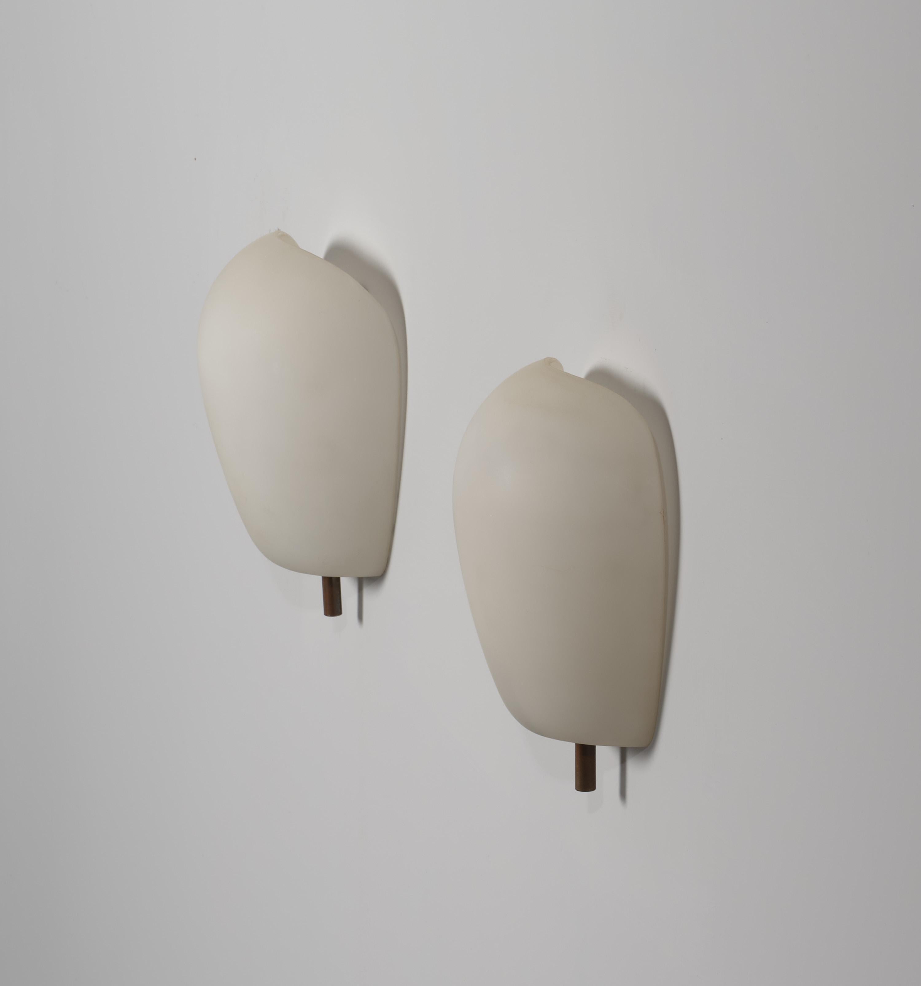 Elegant and refined, this pair of wall sconces showcases iconic Italian design from the 1950s, attributed to the renowned Fontana Arte. Crafted with opaline glass in a graceful shell shape and adorned with brass details, these sconces exude timeless