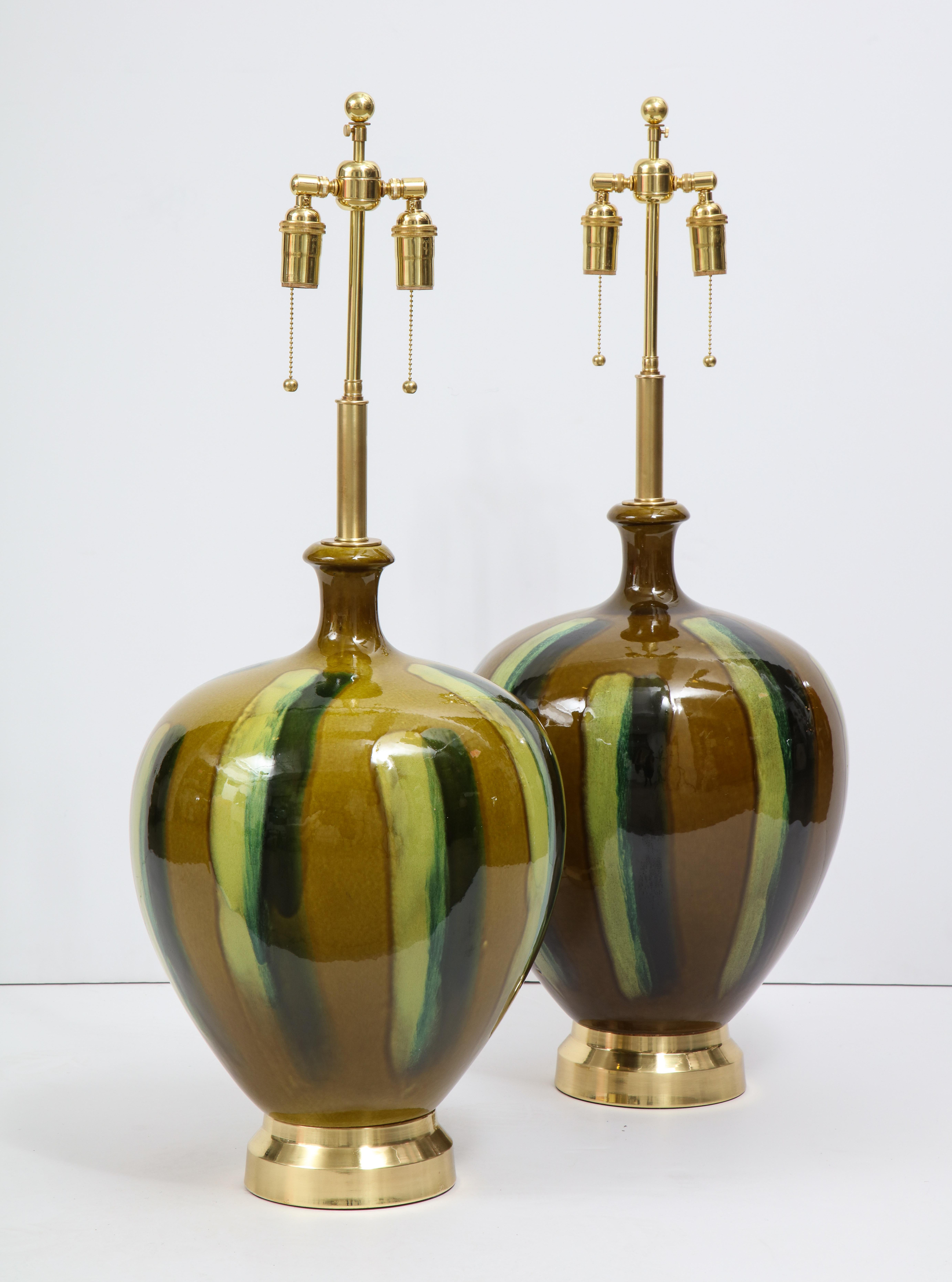 Pair of large Italian ceramic lamps with a beautiful drip glazed finish on polished brass
bases. The lamps have been newly rewired with brass double clusters.