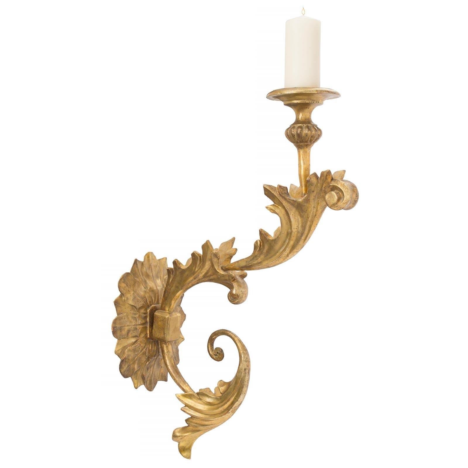 A very decorative and large scale pair of Italian early 19th century giltwood Bras de Lumière sconces. Each sconce has an attractive oval foliate gilt back plate supporting the impressive and fanciful ’S’ scrolled arm. The arm has three large