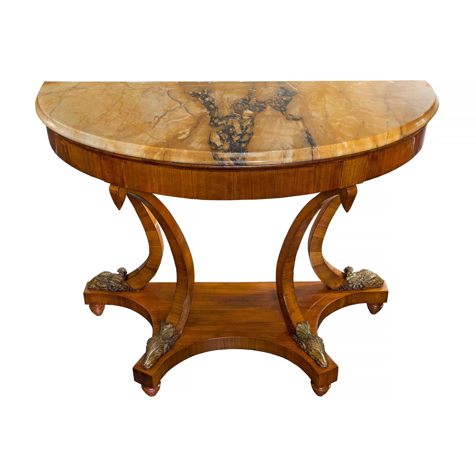 Une incroyable paire de consoles indépendantes néo-classiques italiennes du début du XIXe siècle en noyer, marbre et demi-lune polychrome. Chaque console est surélevée par des supports anglés en forme de topie, sous un étage inférieur dont la façade