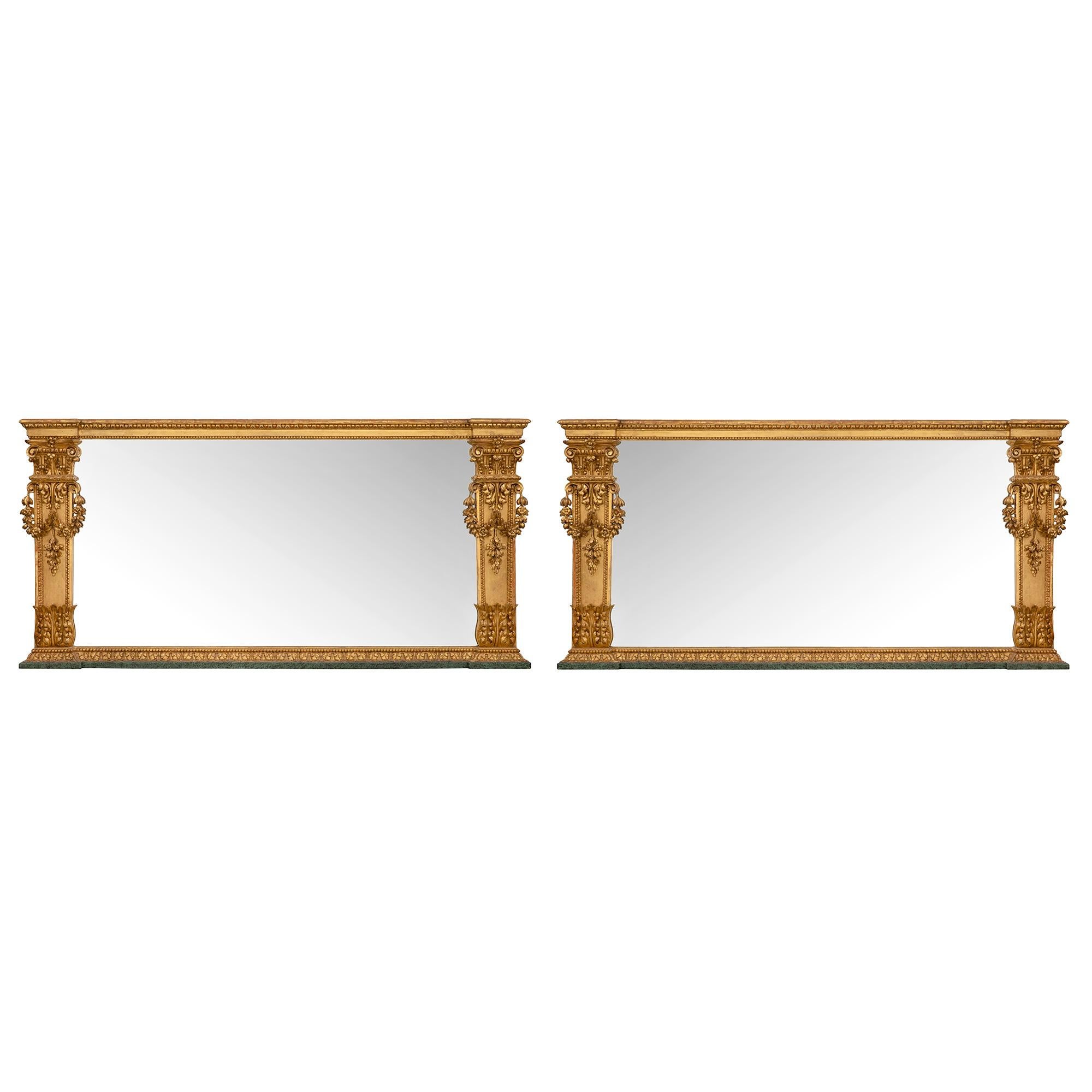 Une paire spectaculaire et de grande taille de miroirs italiens en bois patiné et doré du début du XIXe siècle. L'exceptionnelle paire de miroirs repose sur des socles en faux marbre vert peint, sous un bandeau en bois doré orné de feuilles de