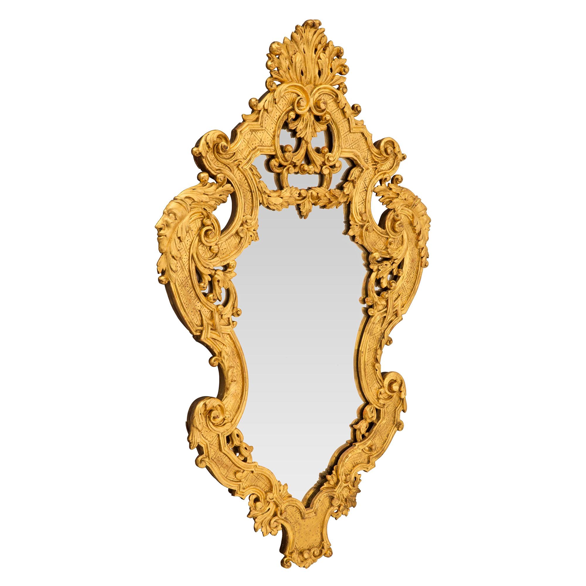 Une paire exquise de miroirs italiens du début du 19ème siècle en bois doré de la Régence. Les plaques de miroir originales sont placées à l'intérieur de mouvements étonnants et très décoratifs, richement enroulés et ornés de grandes feuilles