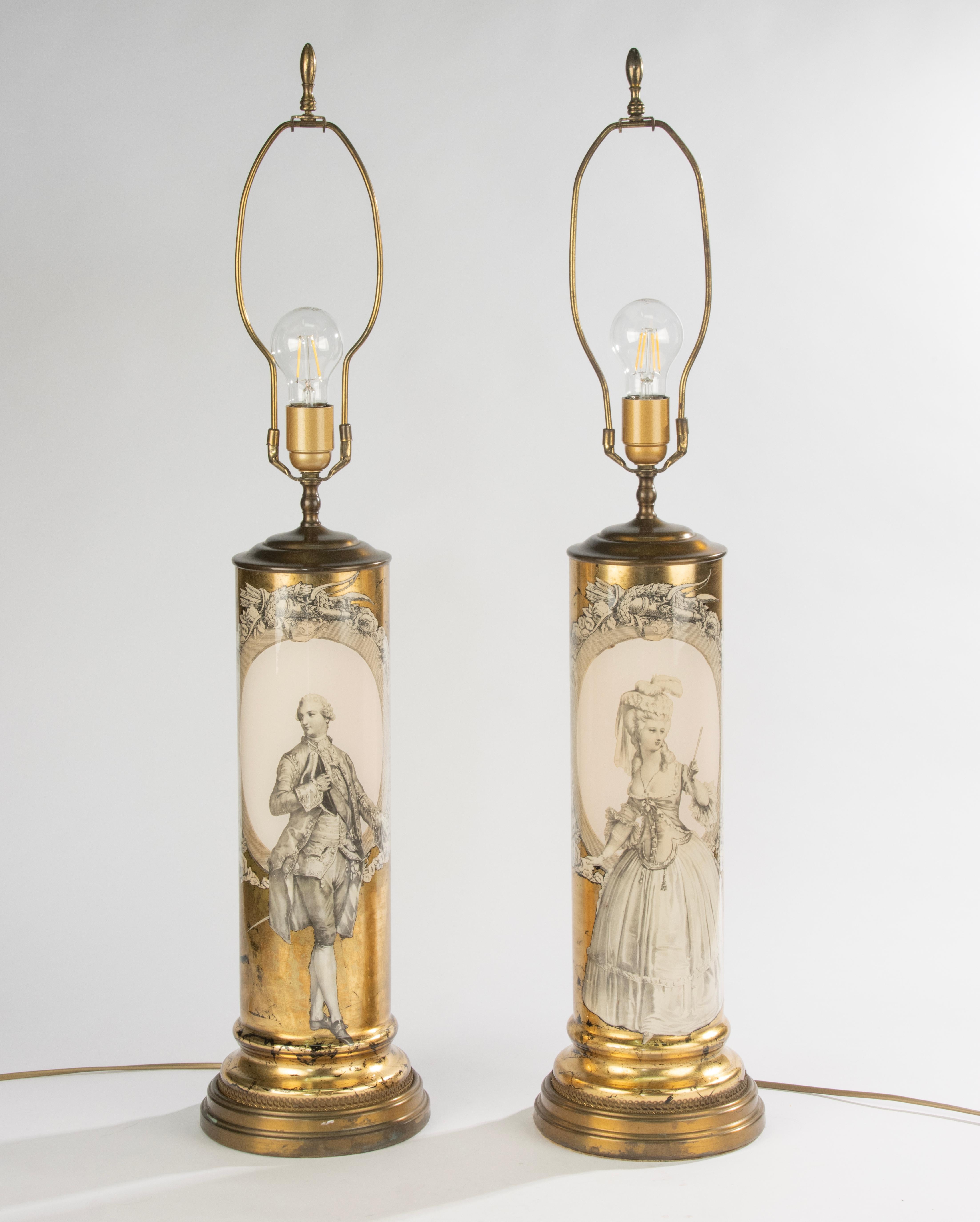 Una straordinaria coppia di lampade da tavolo alte italiane, risalenti agli anni '70. Ogni lampada è caratterizzata da un corpo cilindrico in vetro decorato con la tecnica églomisé, che mostra raffigurazioni finemente dettagliate di un uomo e una