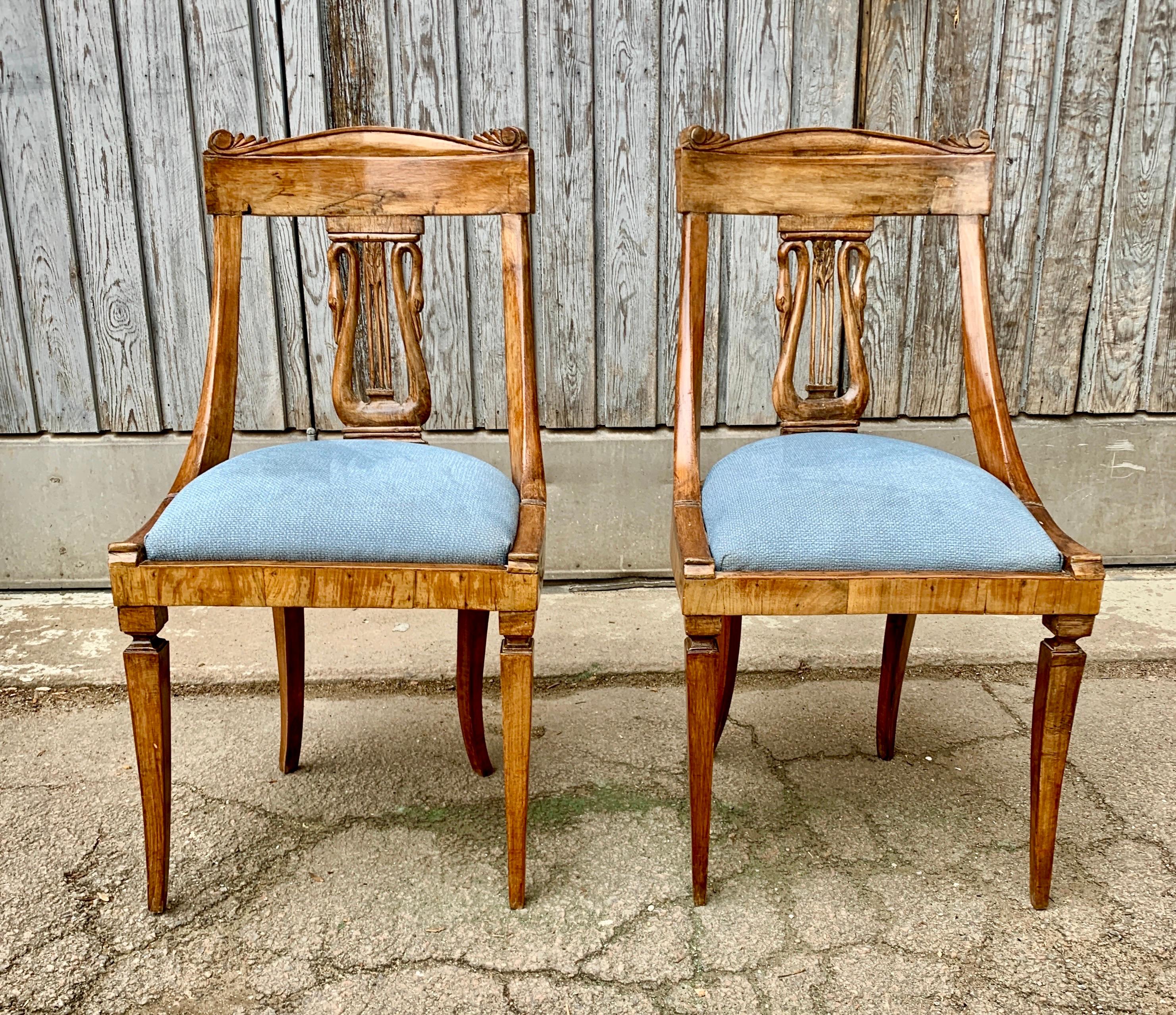 Paire de chaises de salle à manger Empire italiennes du début du 19e siècle en noyer massif.
Cette paire de chaises toscanes, dont le dossier est orné d'un cygne, a probablement été fabriquée dans la ville de Lucques. Cette ville est connue pour ses