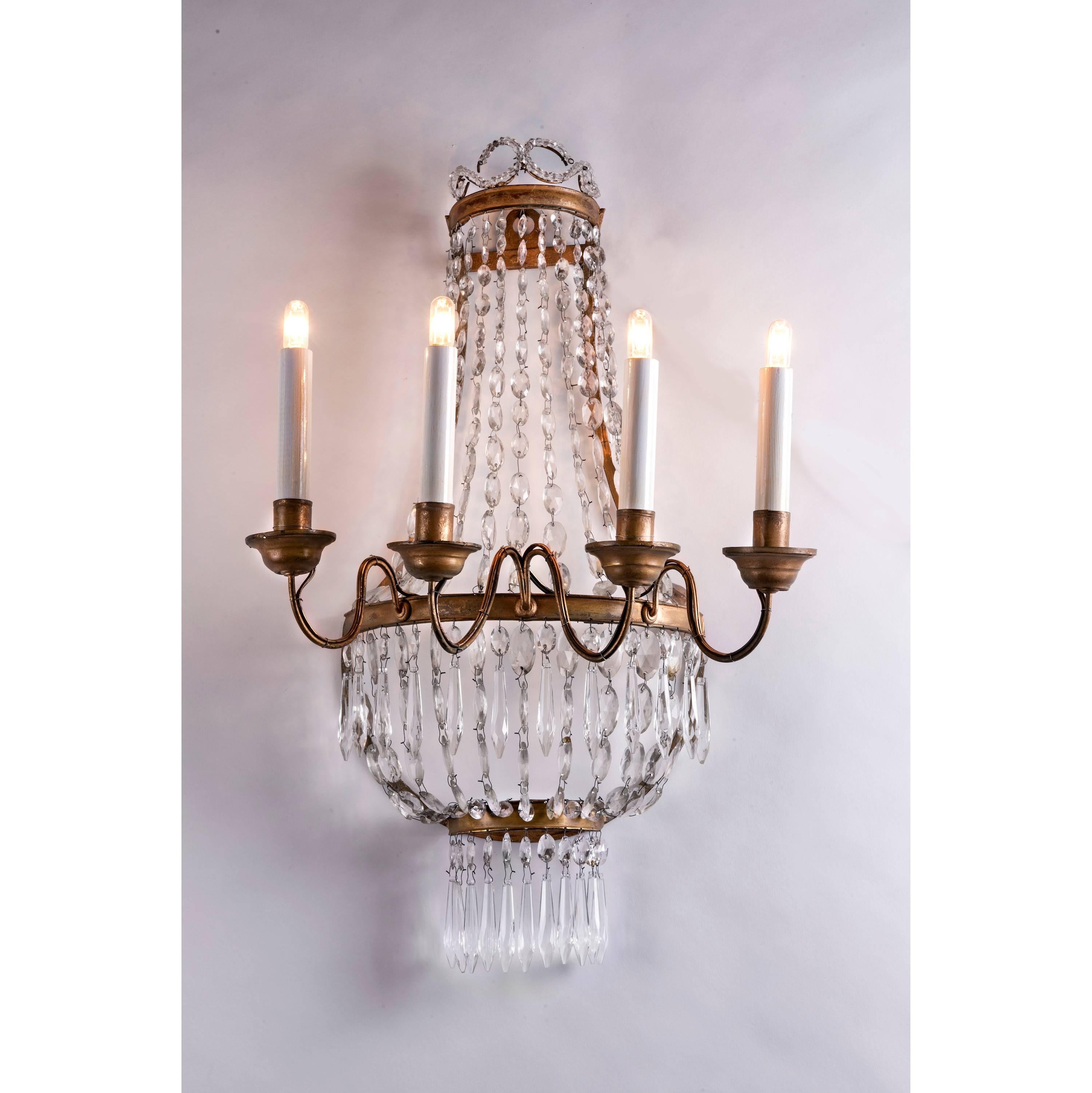 Pair of 19th century Empire crystal four-light sconces, Italian wall candle holders with a gilt iron basket frame, future with beaded crystal chains, in good condition, new wiring. They come from a charming rural house near the medieval Malaspina’s