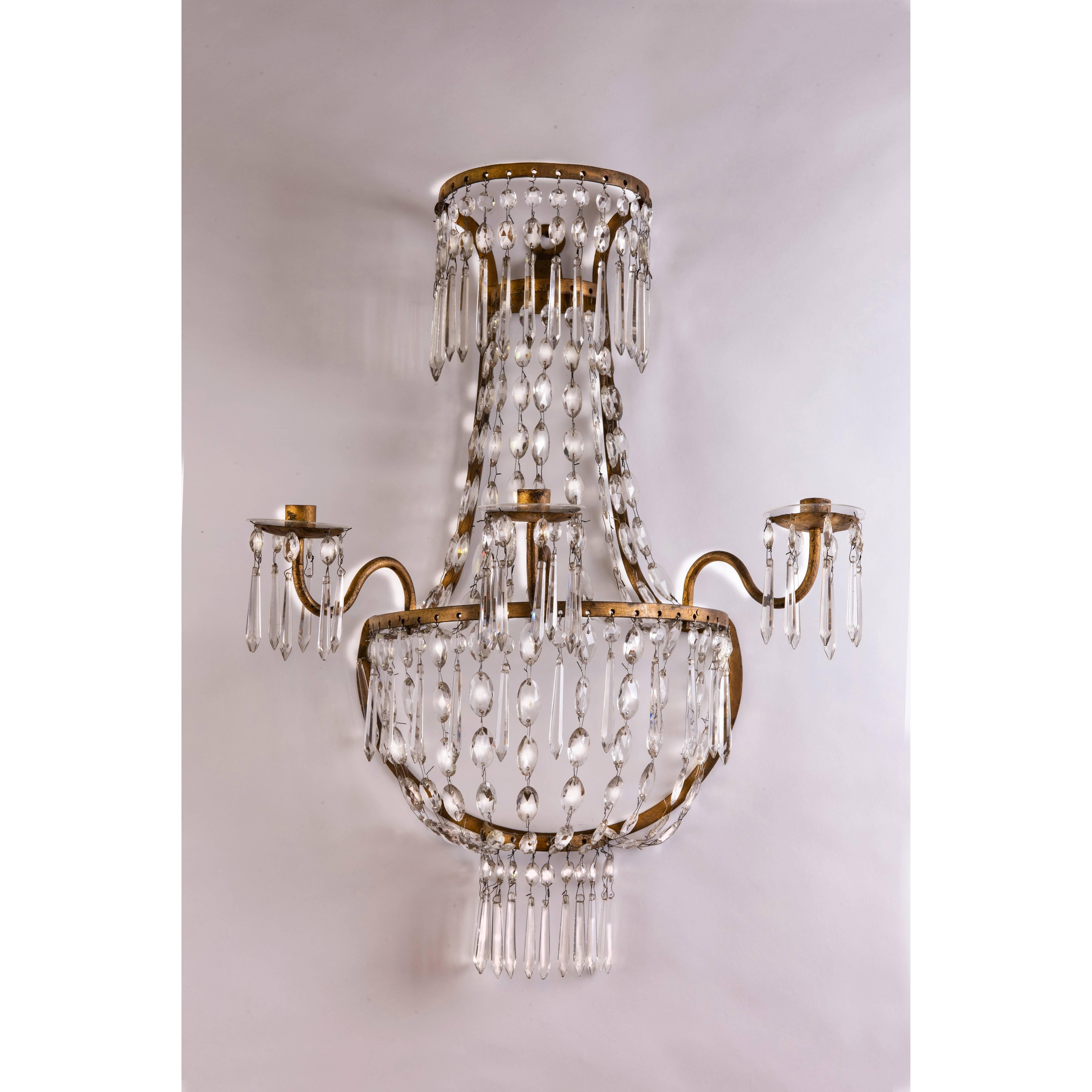 Pair of 19th century Empire crystal three-light sconces, Italian wall candleholders with a semi-circular gilt iron basket frame, future with beaded crystal chains and a new mirror plate on a shaped wooden panel the back,  useless to cover wiring