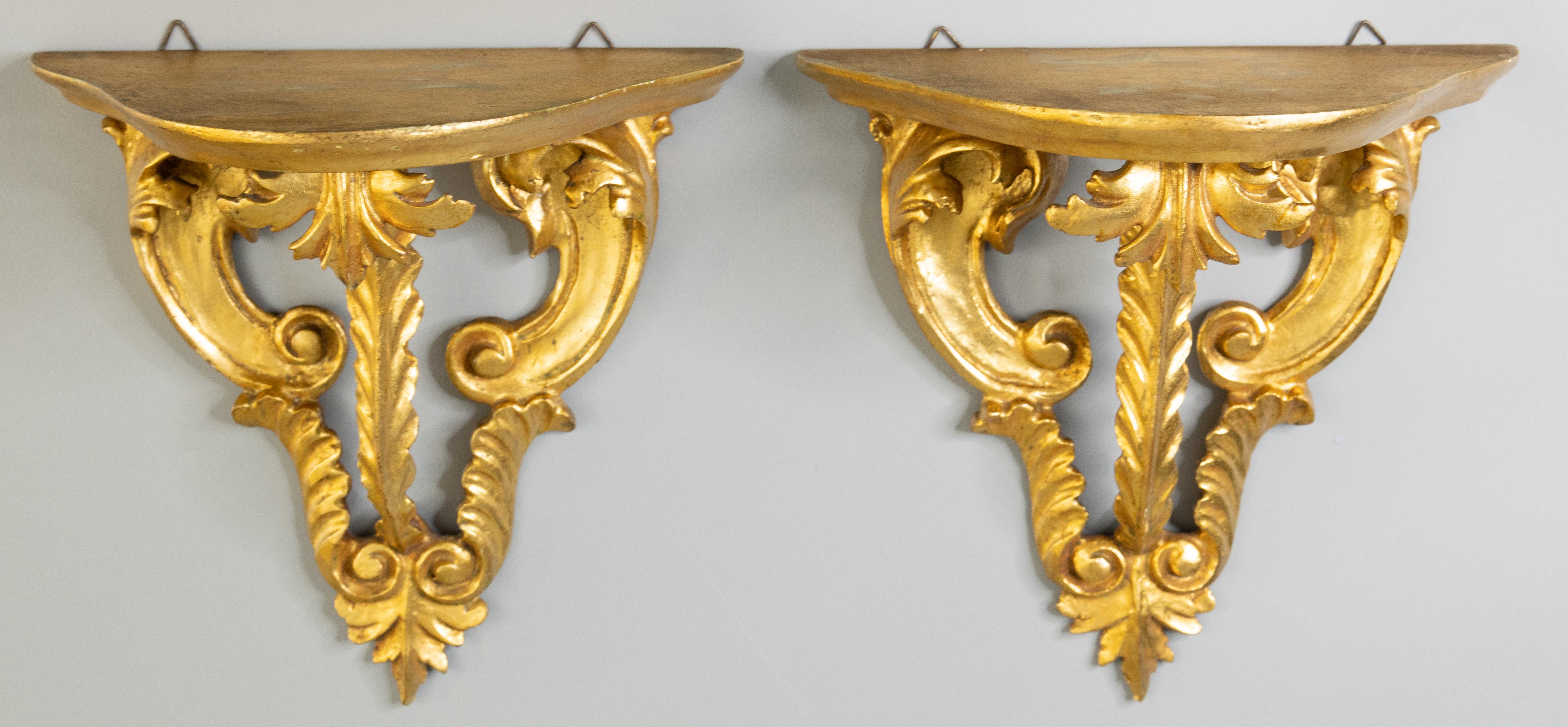 A lovely pair of vintage Italian gilded wood wall brackets or shelves from Florence, Italy, circa 1950. These stylish brackets have a hand carved scrolling acanthus leaf design and beautiful gilt patina. They are perfect for displaying decorative