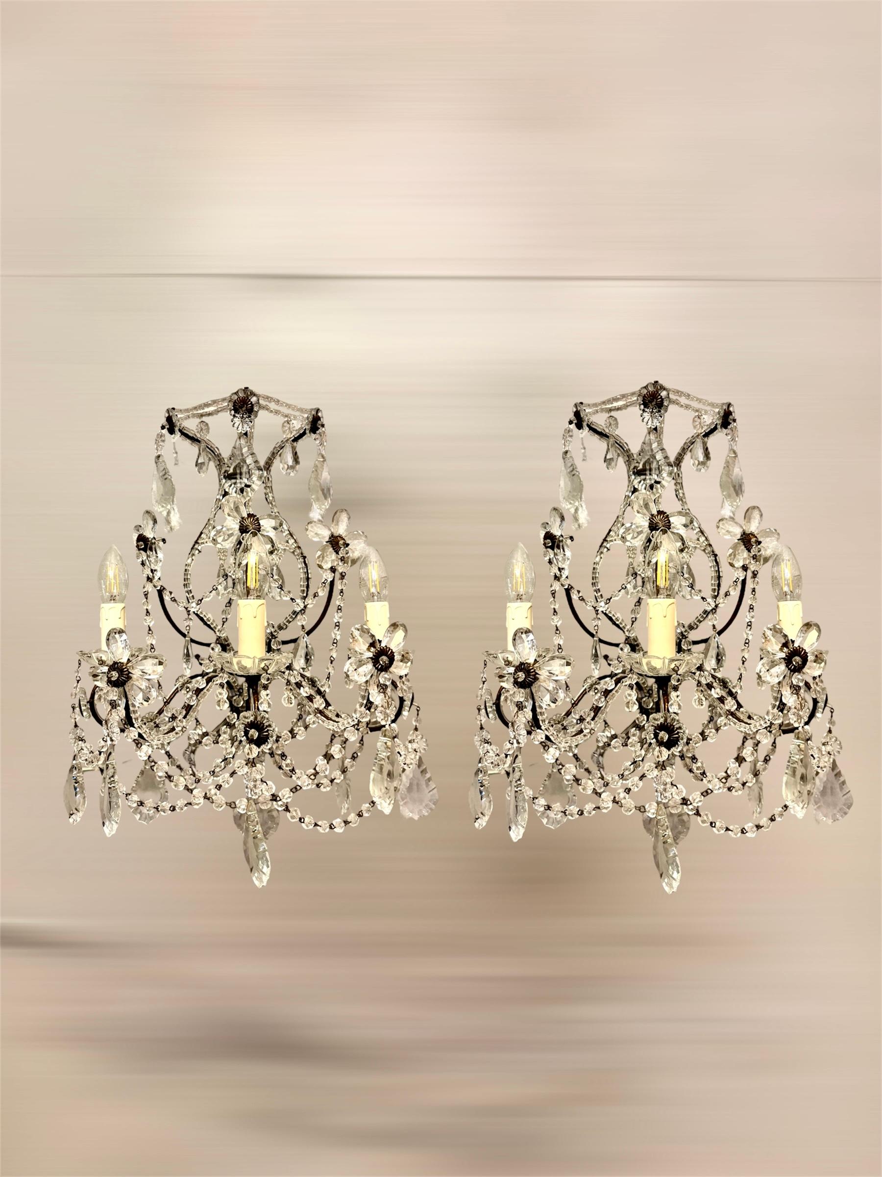 Este elegante par de apliques florentinos italianos de la década de 1950 muestra la refinada artesanía y la belleza atemporal típicas del diseño italiano de mediados de siglo. Cada candelabro tiene tres luces, dispuestas en un estilo clásico de