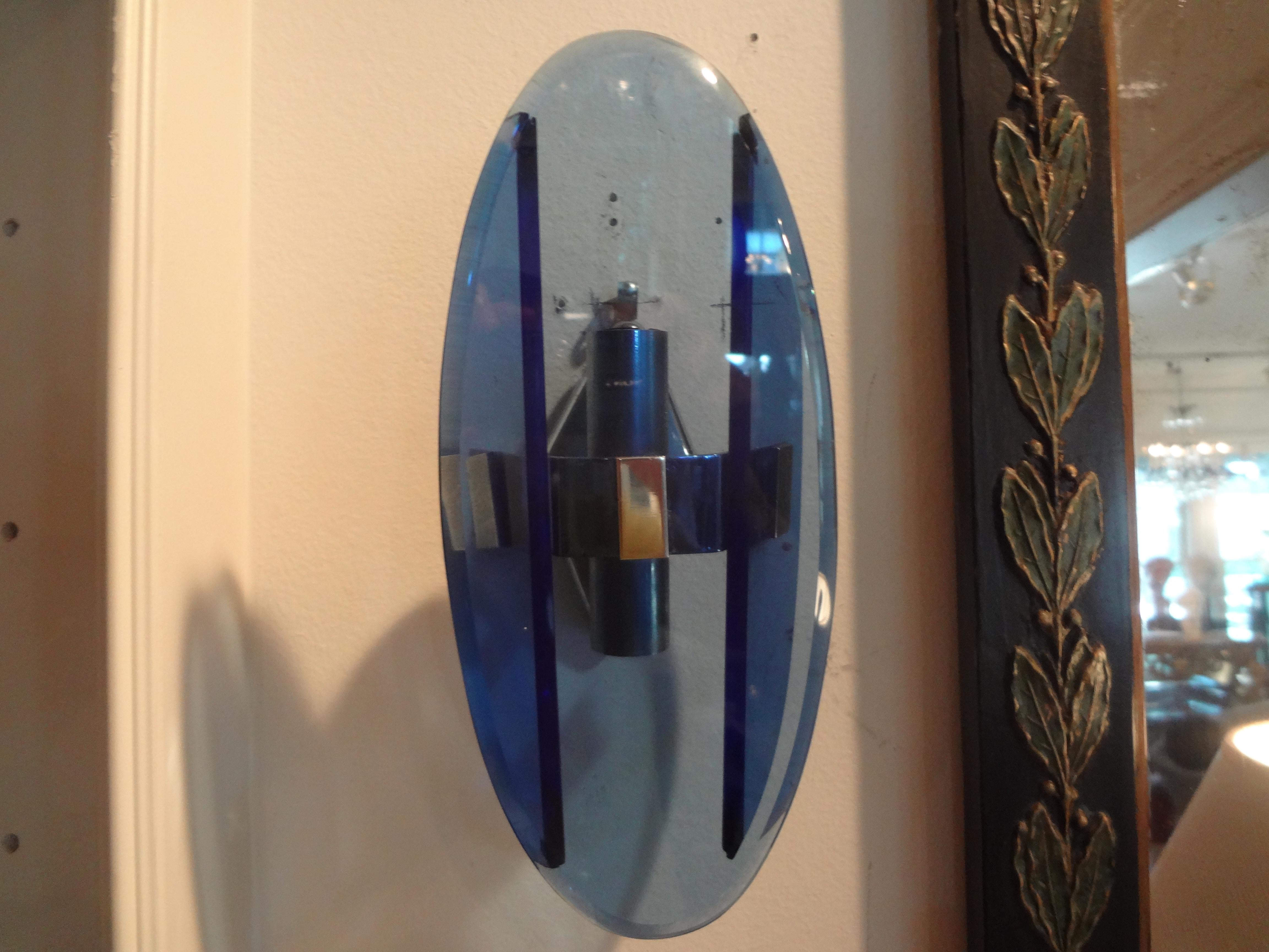Pair of Italian Fontana Arte style blue glass sconces.
Great pair of Italian oval blue glass wall sconces inspired by the work of Fontana Arte. These chic blue glass sconces (possibly Murano glass sconces) have chromed metal frames and have been