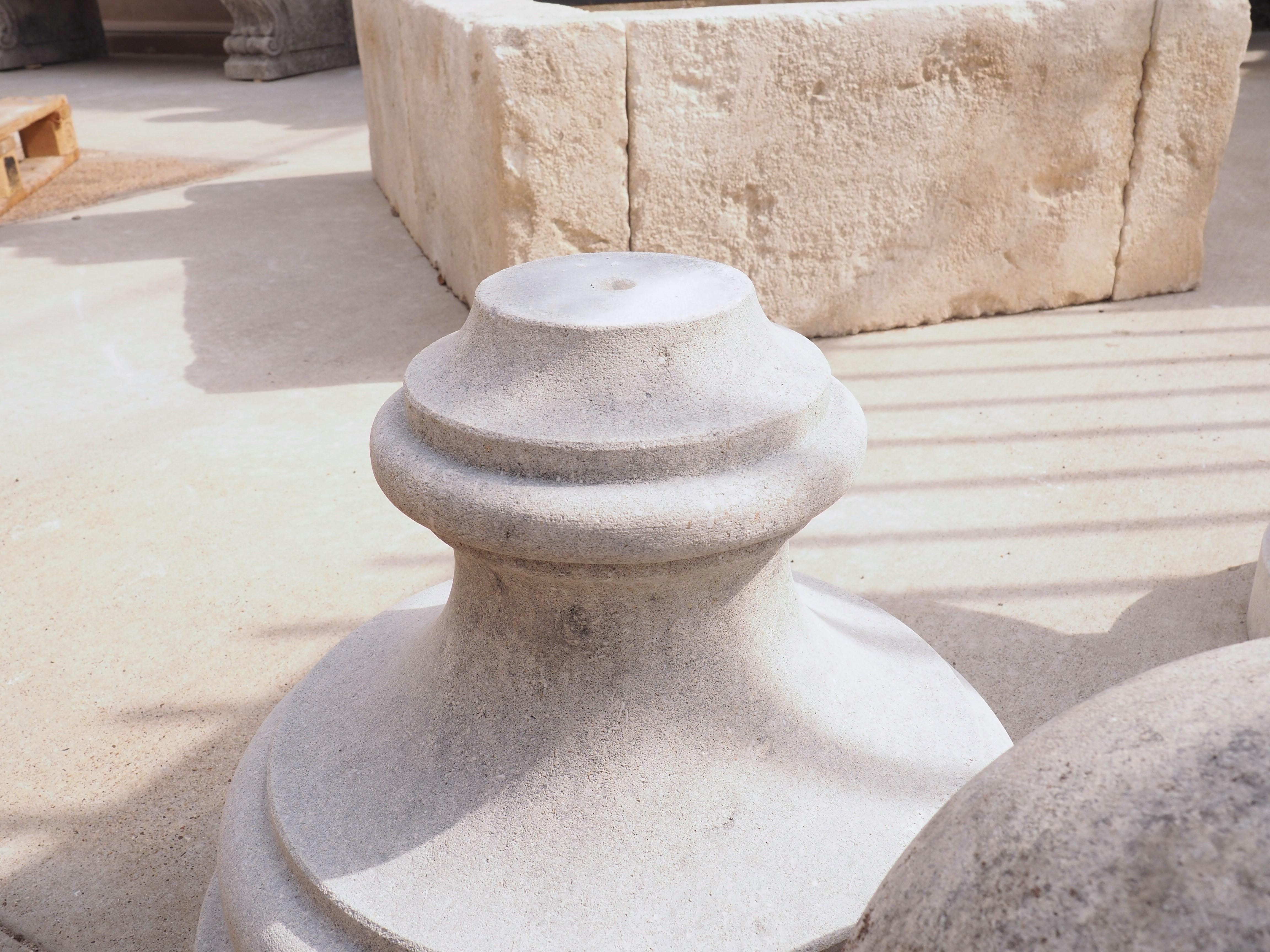 This large pair of garden ball finials have been hand-carved from Italian limestone. Ball finials such as this can often be seen flanking the entry of gardens at Italian villas. Both balls are roughly 13 inches in diameter and sit atop circular