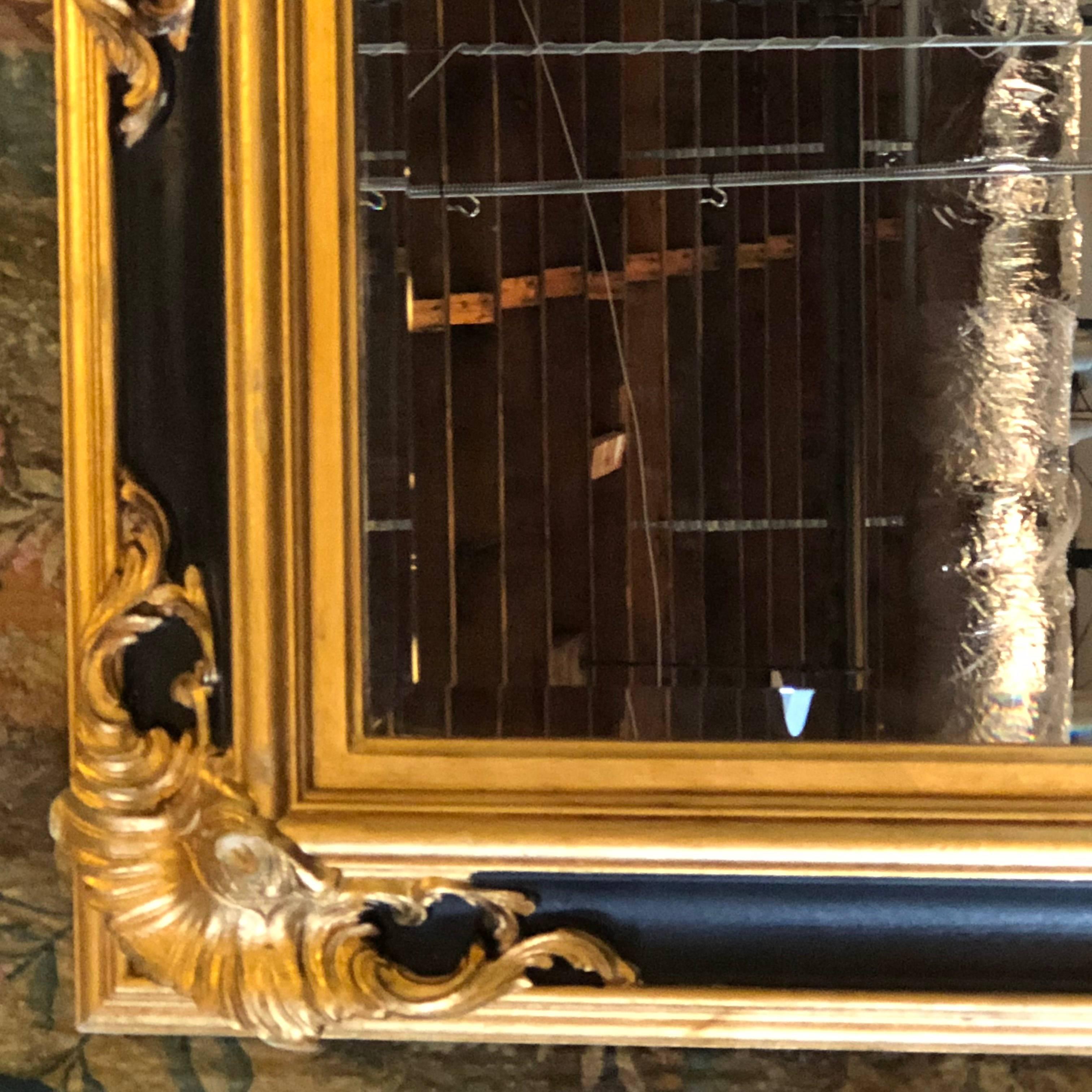 Pair of Italian gilt and ebony beveled monumental console or wall mirrors. This large pair of Labarge wall or console mirrors are wonderfully detained with an ebony centre decorated frame having gilt gold and green decorated edges.