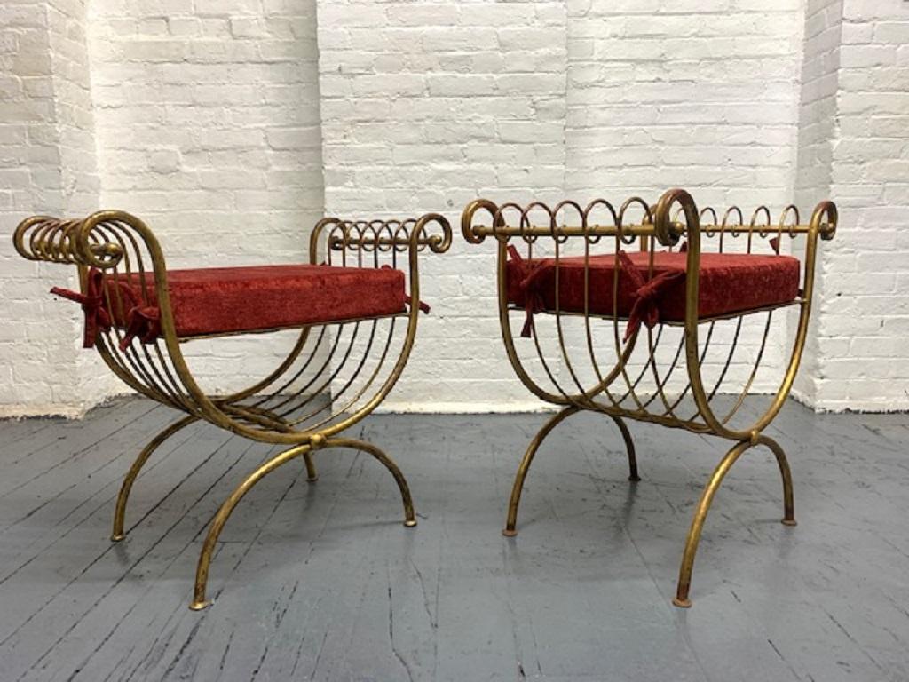 Pair of Italian gilt metal benches with scrolled arms and velvet cushioned seats. 
One is slightly taller.
Taller bench measures: 24.25 H x 14.5 D x 26 W. Seat height is 20 H
Shorter bench measures: 23.5 H x 14 D x 26 W. Seat height is 19 H.