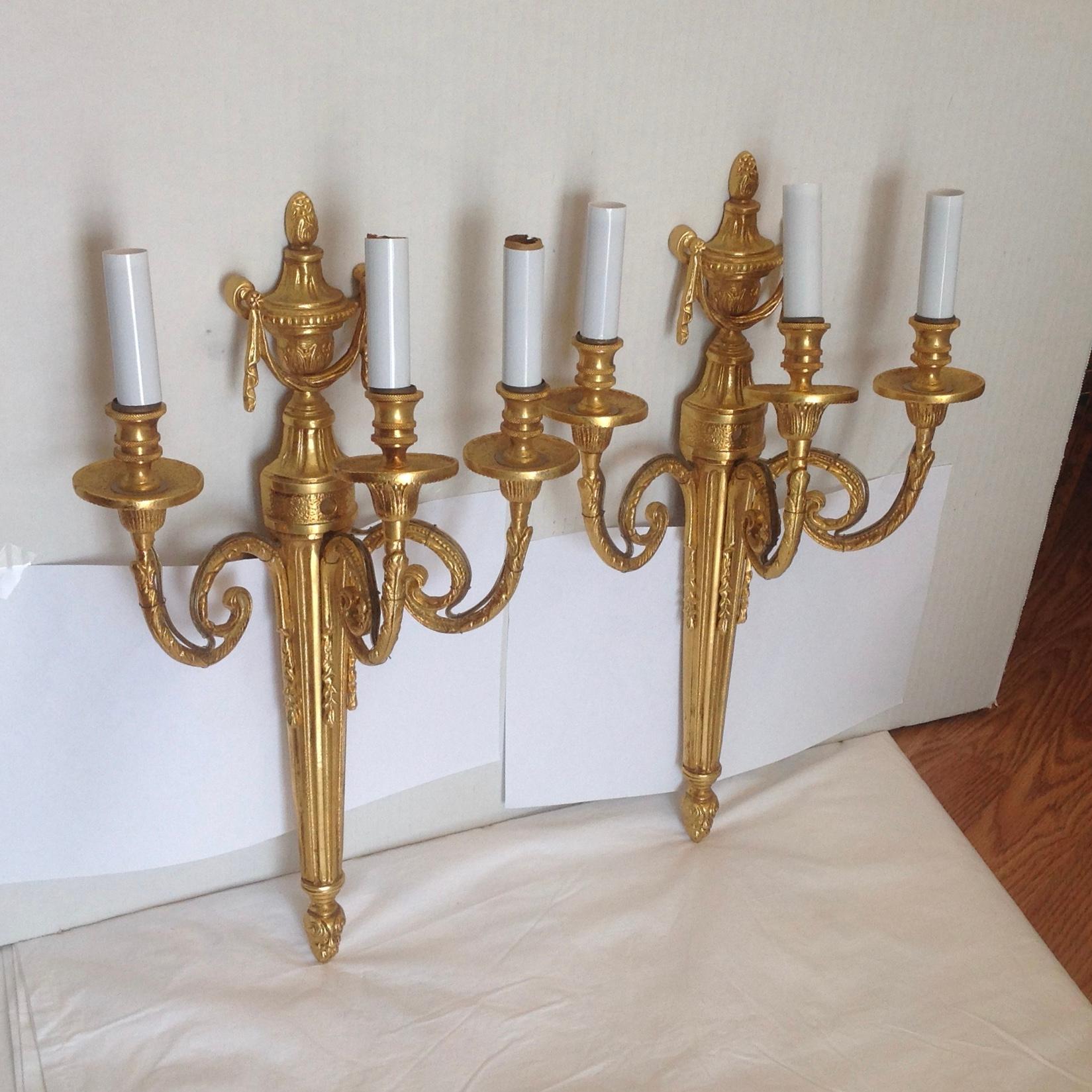 Finely cast neoclassic sconces - fashioned with draped urn tops and designed with 3 lights each. Superb quality.