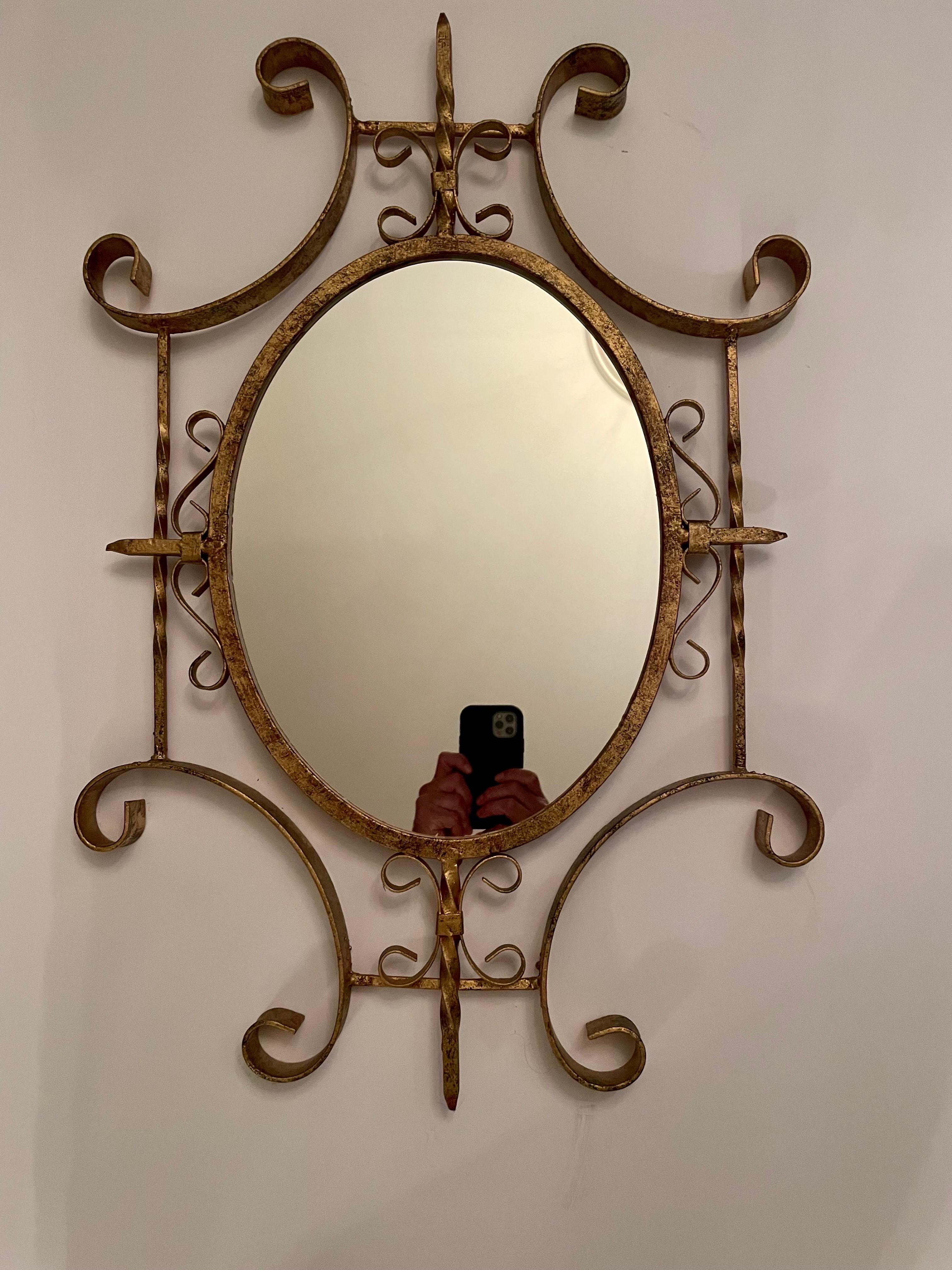 Pair of Italian Hollywood Regency Gilt Iron Mirrors. In good overall condition with newly replaced mirror in each.   Scrolled Gilt Frame measures 28