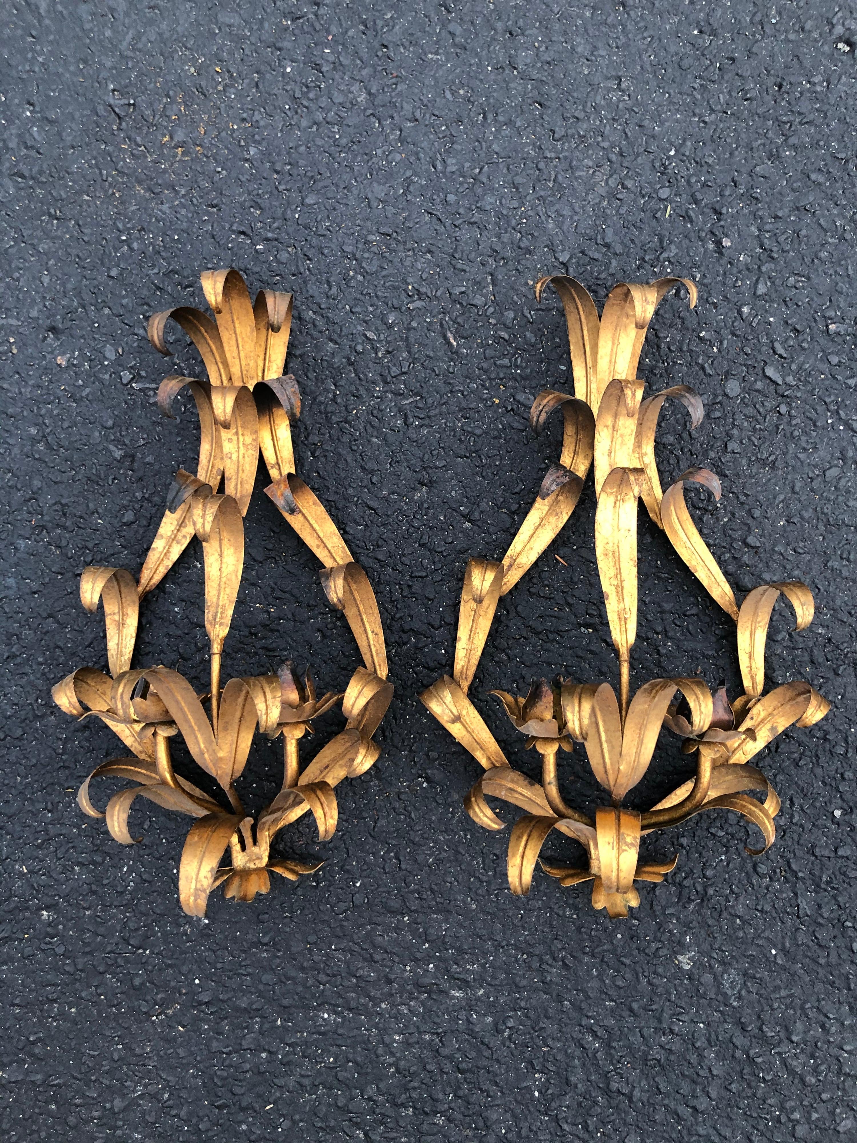 Pair of Italian gilt iron wall sconces. Romantic sculptural floral design which holds two candles each. Can also be wired for electricity. Perfect for a romantic bathroom or bedroom. Adorn on your wall flanking a hallway mirror or a mantle mirror.