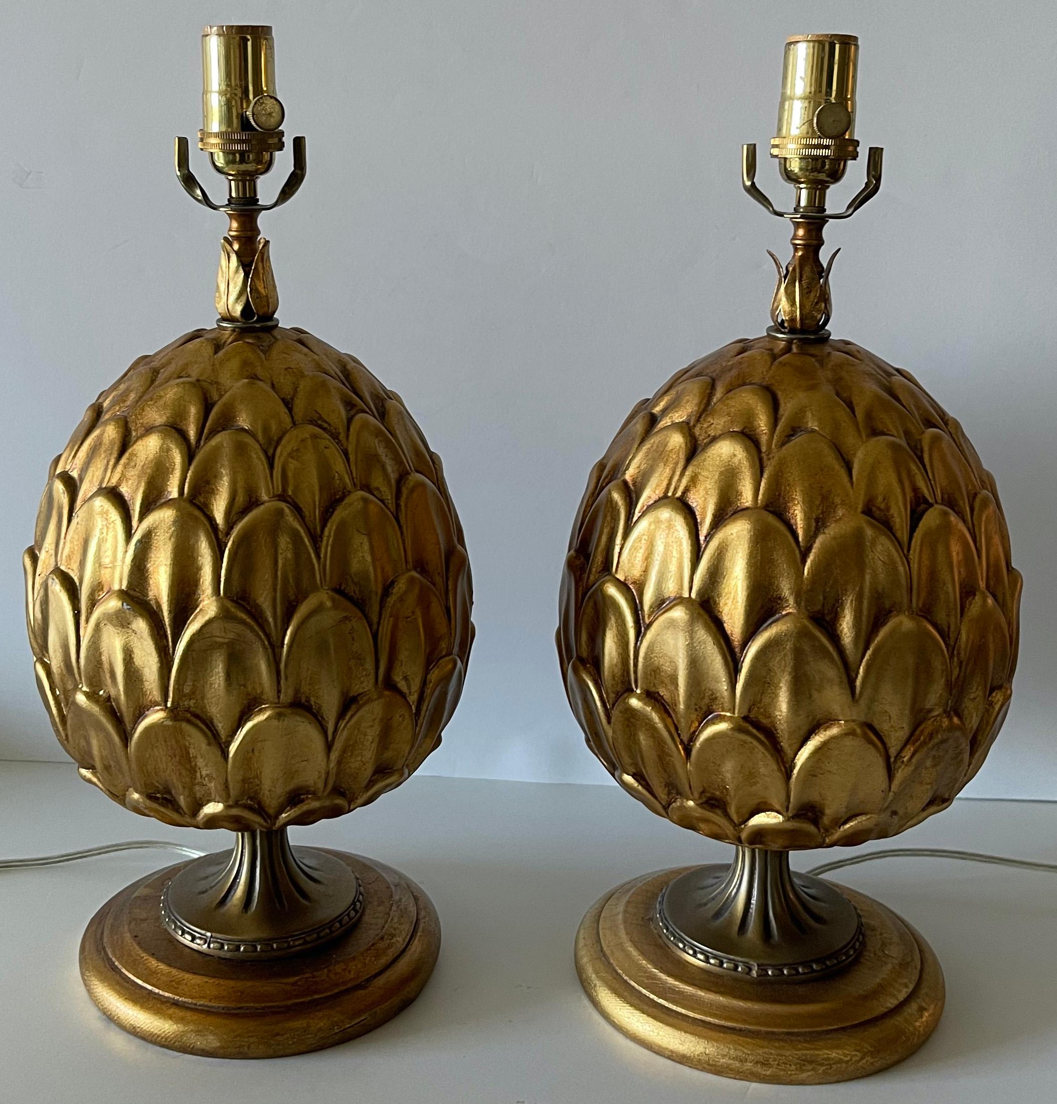 Paire de lampes artichauts italiennes en métal doré. Artichaut en métal doré sur une base ronde tournée en bois doré. Le câblage a été refait à neuf avec de nouvelles prises en laiton. Chaque lampe fonctionne avec une ampoule (non incluse). 