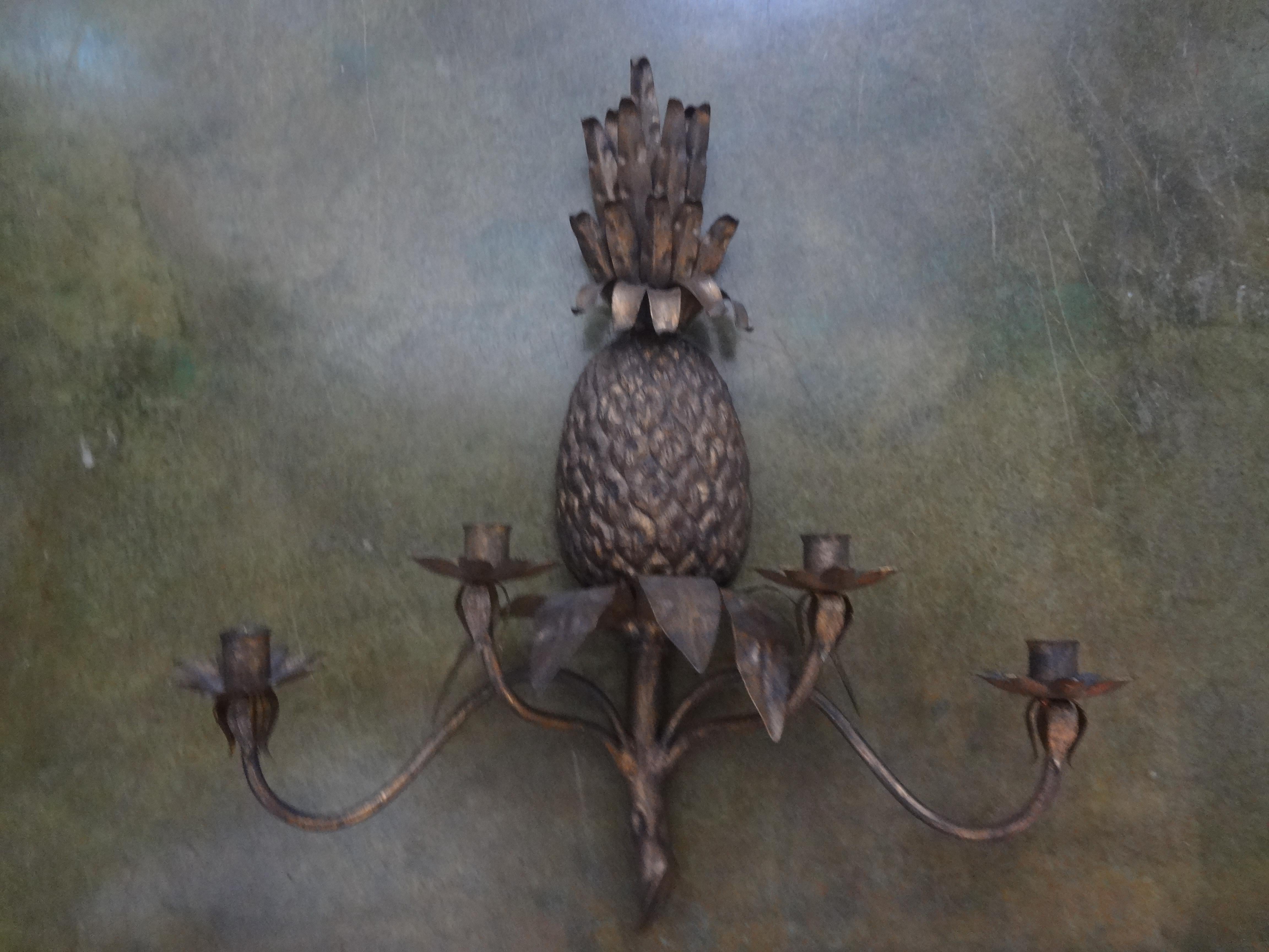 Large pair of Italian Hollywood Regency gilt metal pineapple sconces. This great pair of realistic Italian midcentury four-light sconces are made of heavy gauge gilt iron and tole. Currently candle sconces but could easily be electrified if desired.